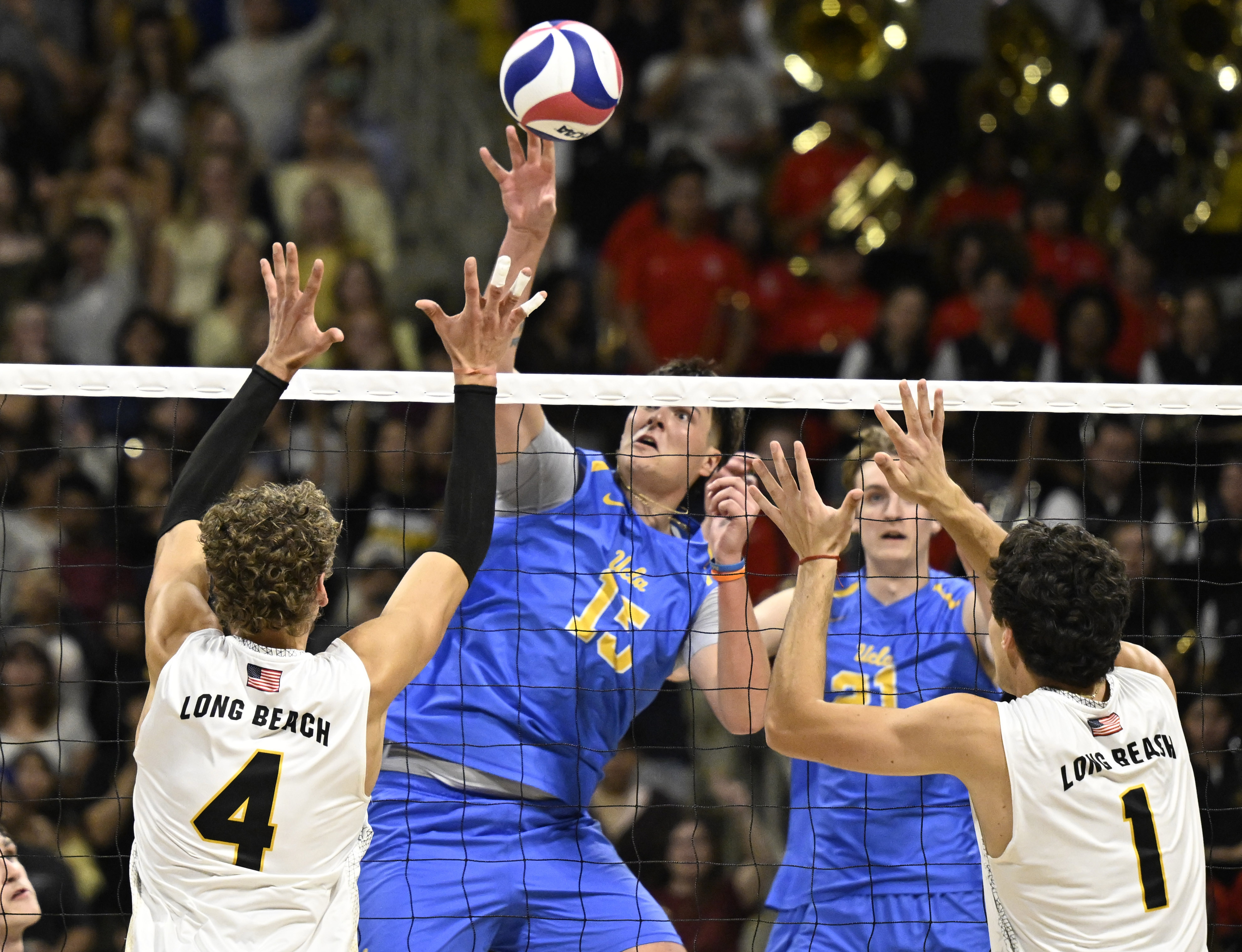UCLA middle blocker Christopher Hersh (15) hits against Long Beach...