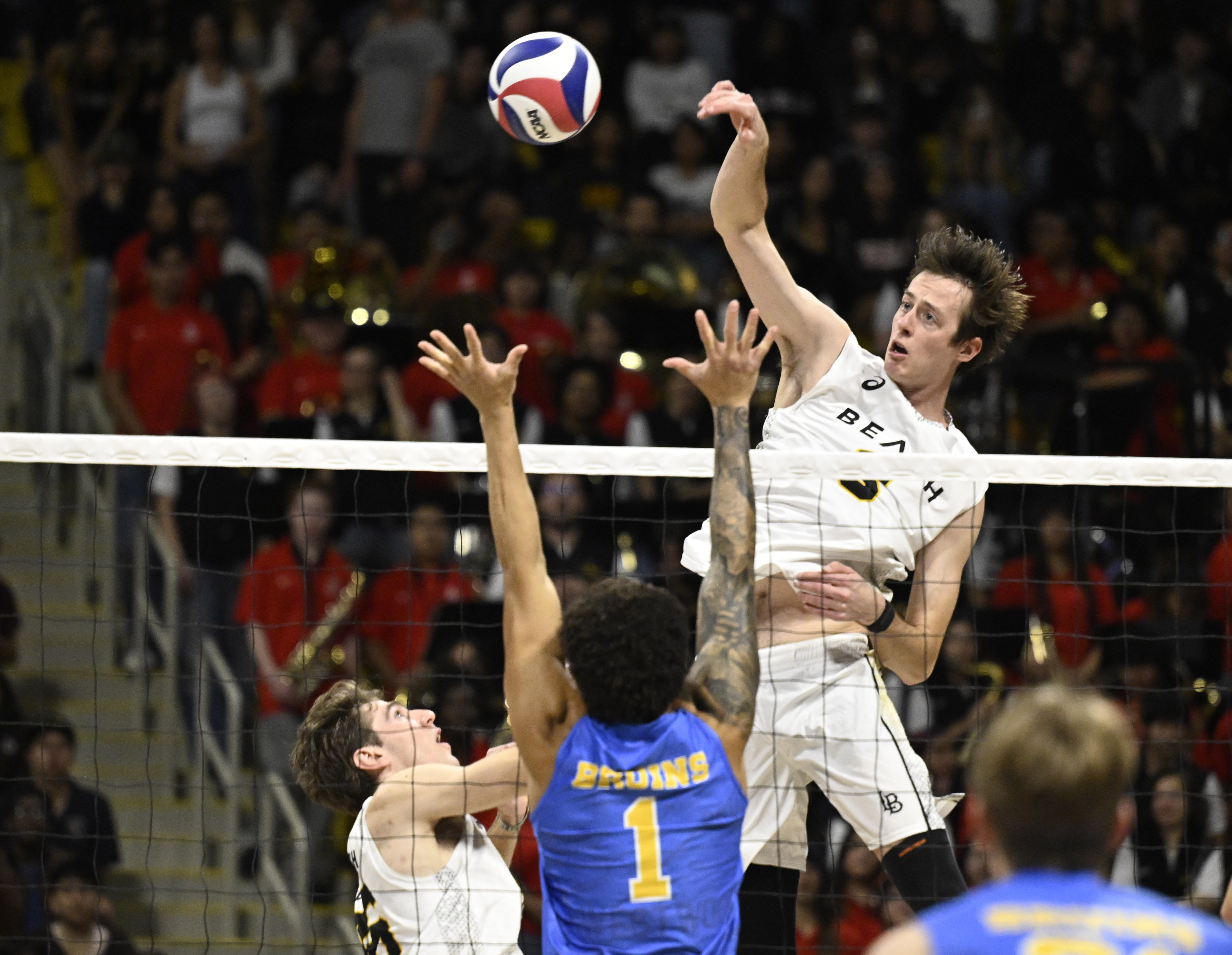 Long Beach State middle blocker Ben Braun, top, spikes the...