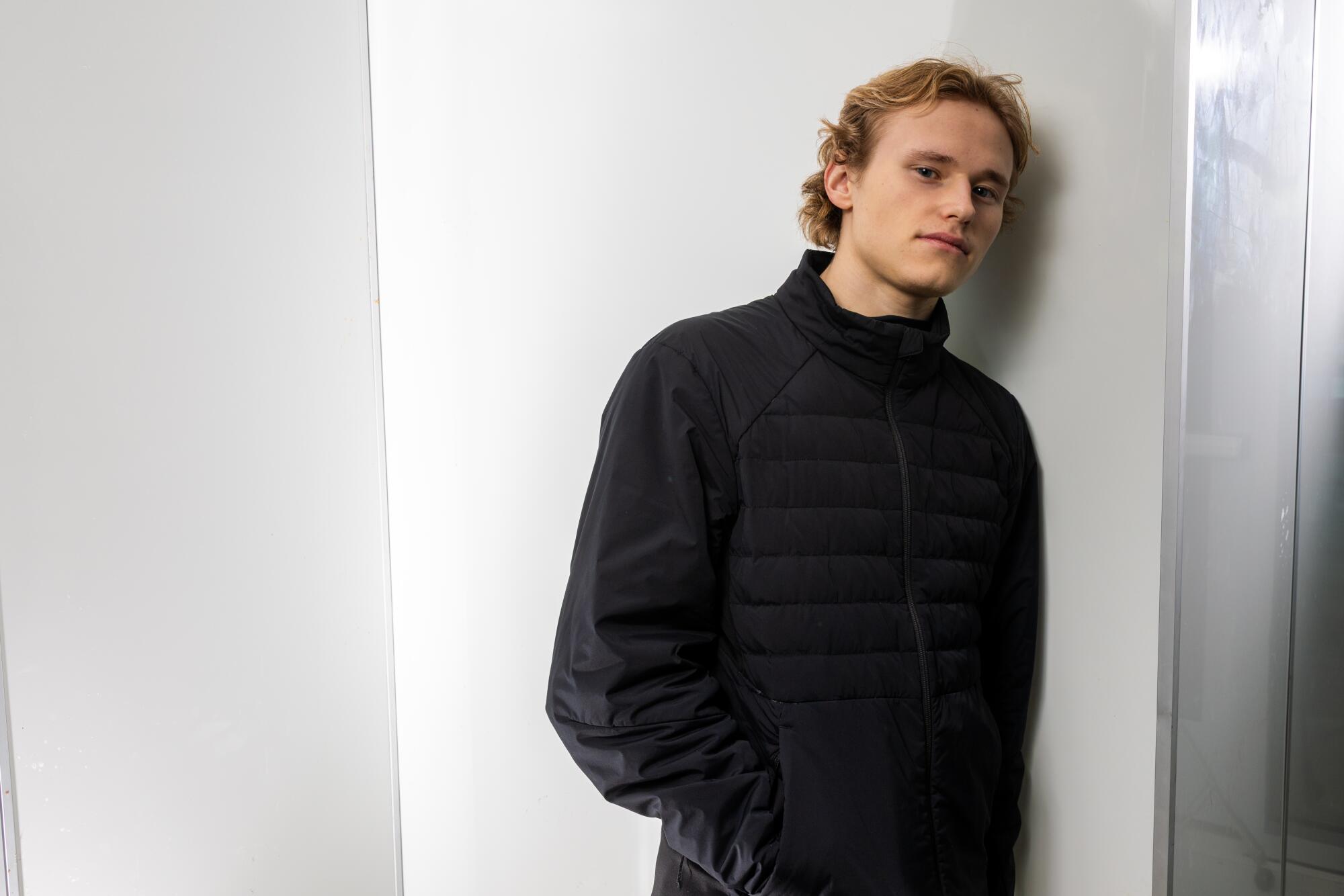 Ilia Malinin stands off the ice after training.