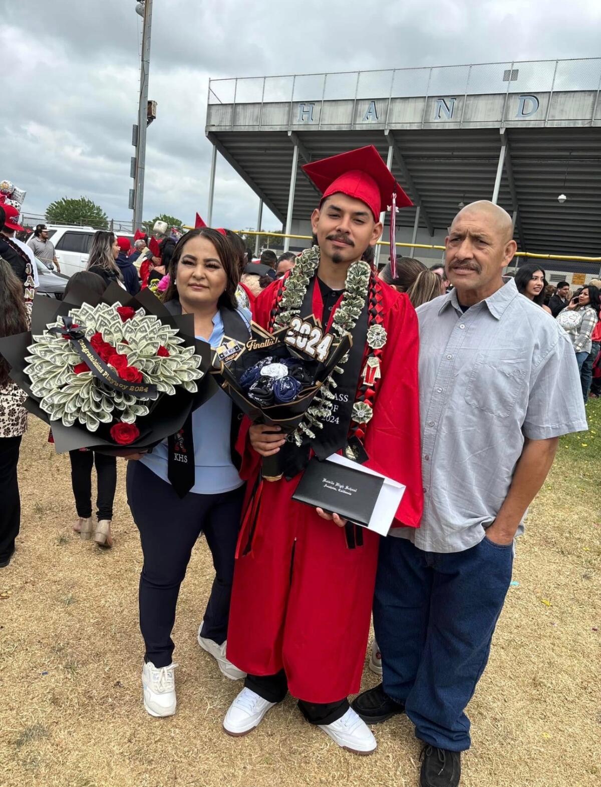 Alberto Arzola with his mom and dad at high school graduation