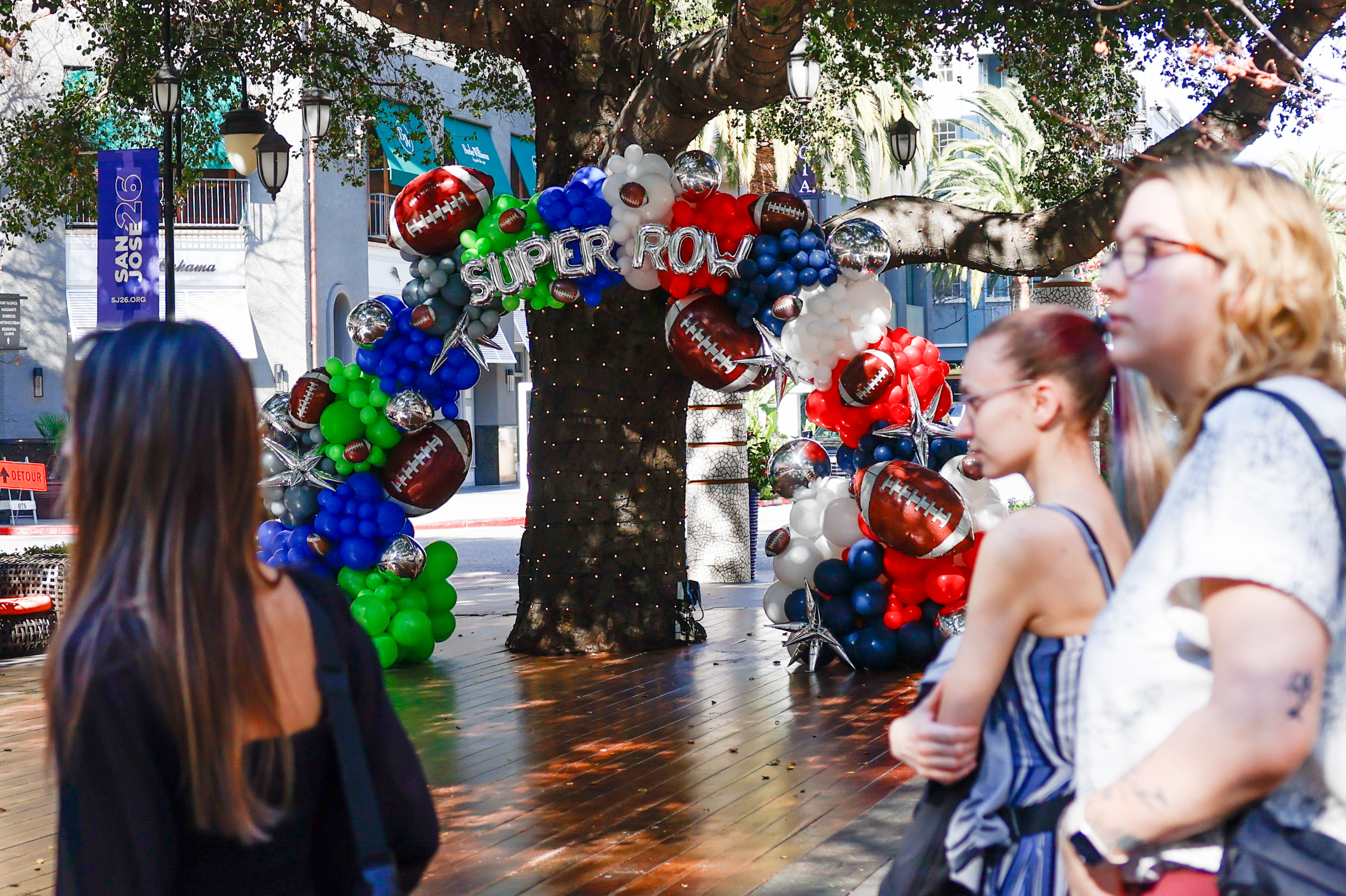People walk past a âSuper Rowâ balloon arch at Santana...