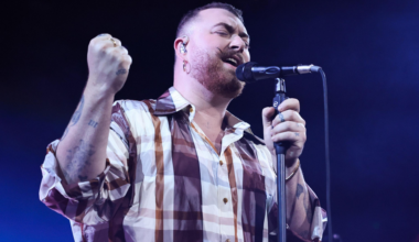 A historic theater with bright red and blue neon "CASTRO" sign and marquee lit up, showing movie titles, framed by an ornate façade at night.
