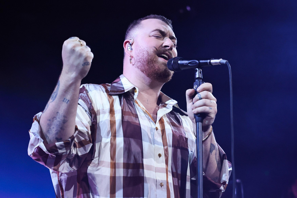 A historic theater with bright red and blue neon "CASTRO" sign and marquee lit up, showing movie titles, framed by an ornate façade at night.