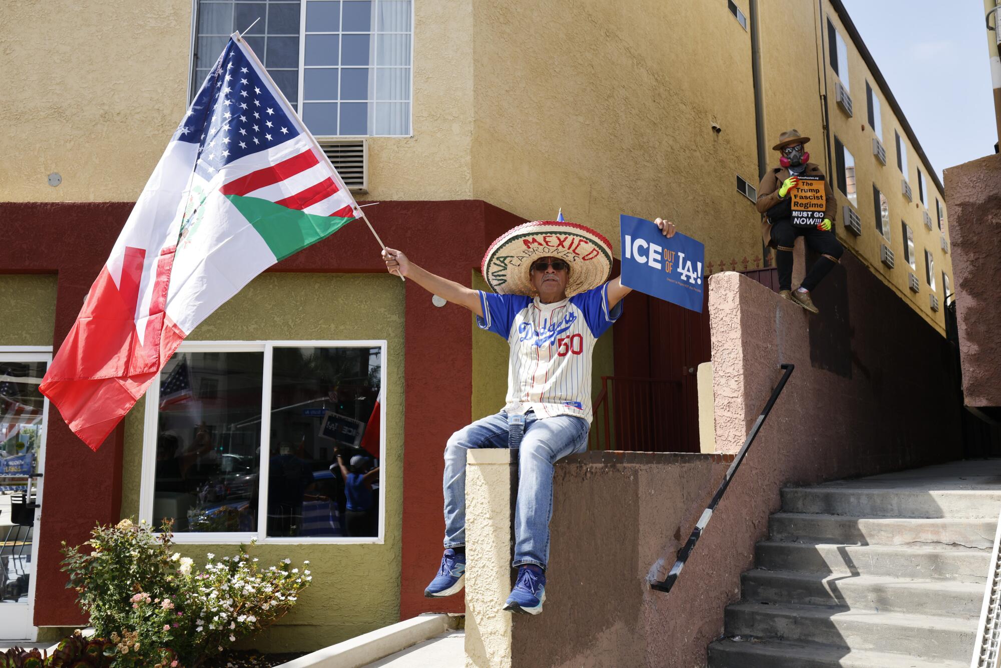 A protestor wearing a Mookie Betts jersey and waving a Mexican and American flag stitched together protests ICE.