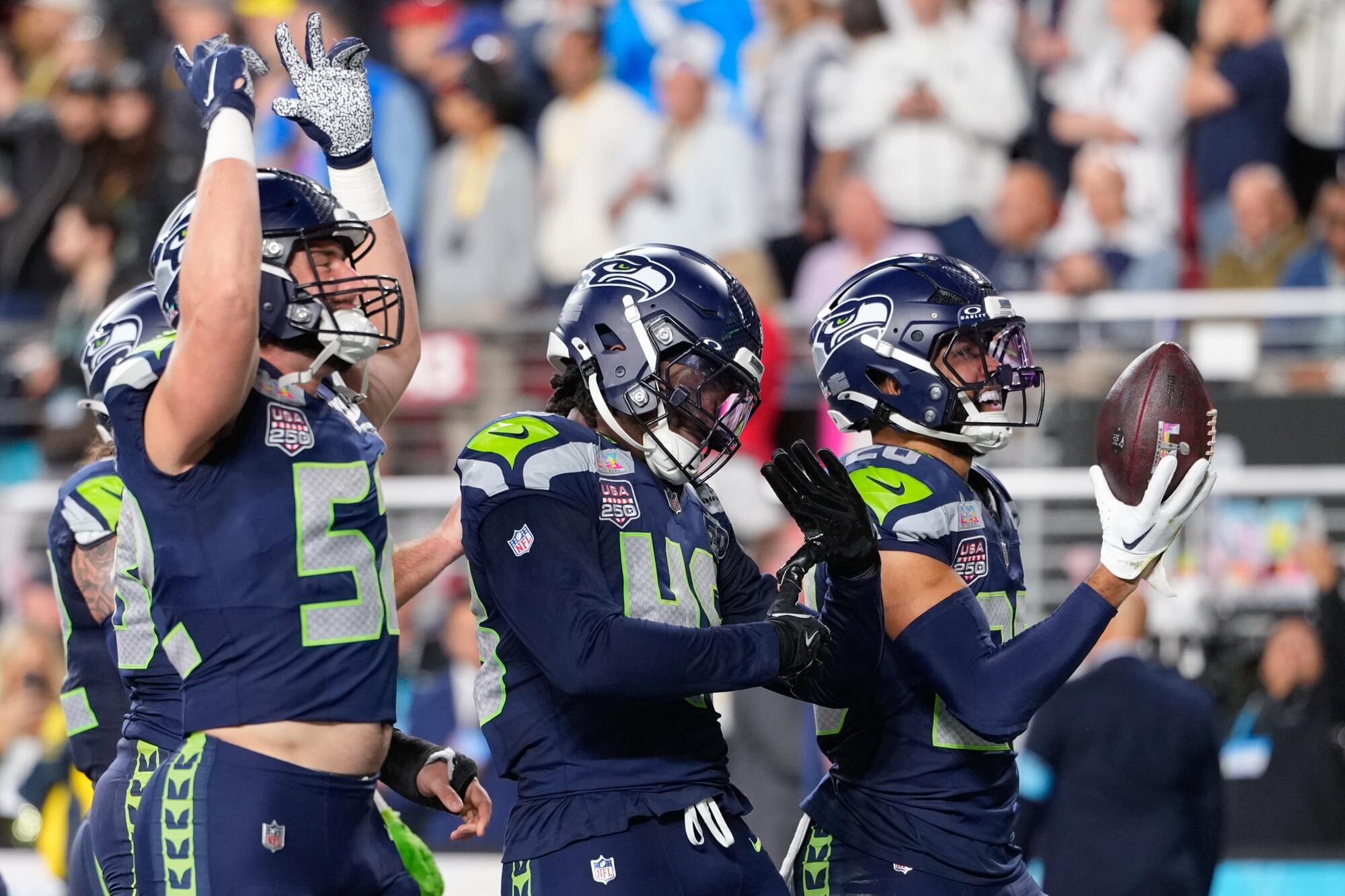 Seattle Seahawks safety Julian Love, right, celebrates with teammates after intercepting a pass 