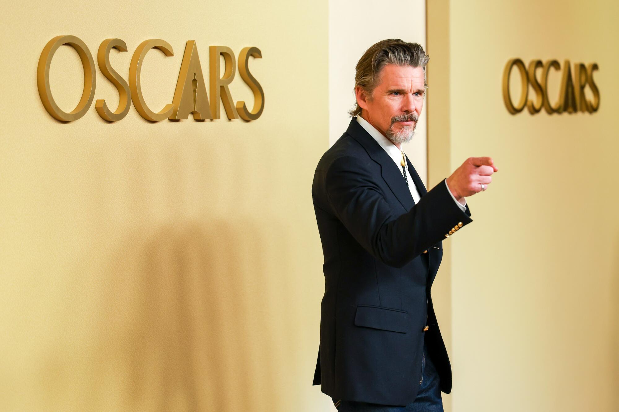 Ethan Hawke points to a photographer. 