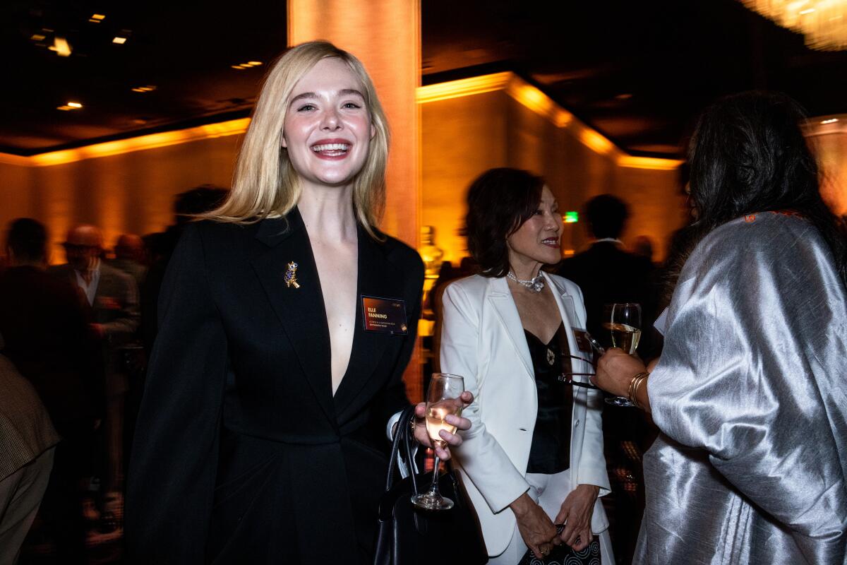 A blond woman smiles at a luncheon.