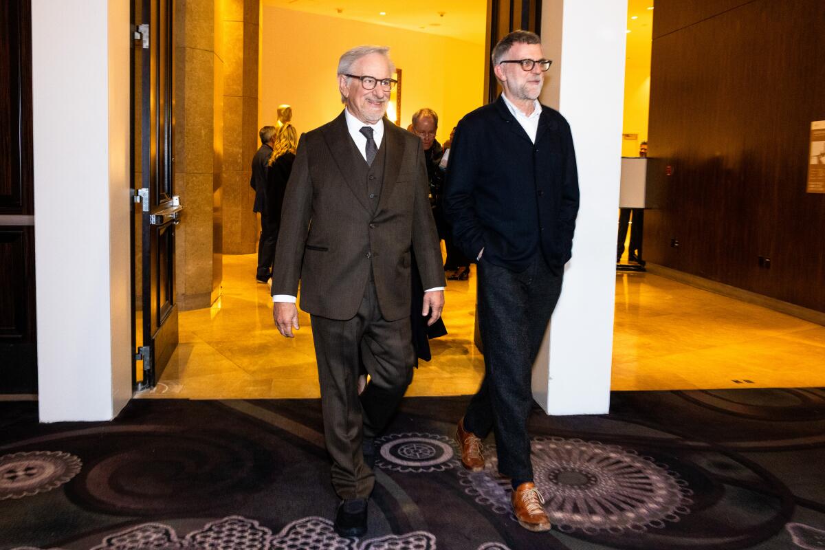 Two men stride into a luncheon.