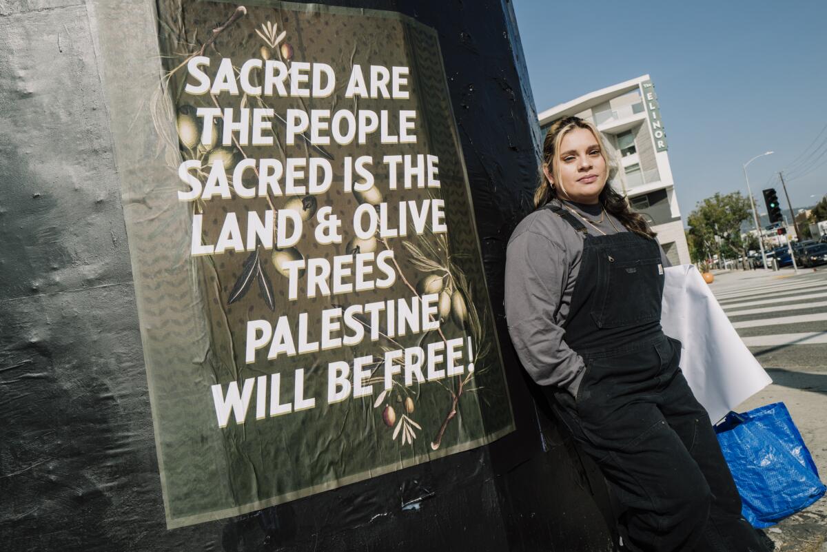 Johanna Toruño stands next to a poster that she designed in support of Palestinians.