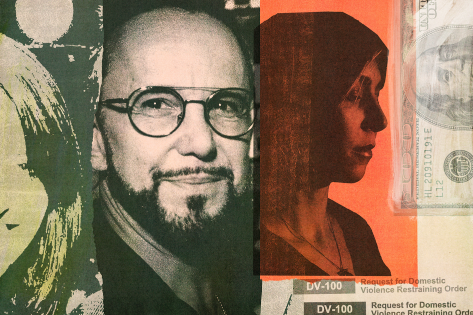 A man and woman dressed in coats embrace and smile on a rooftop patio at night with city buildings lit in the background.
