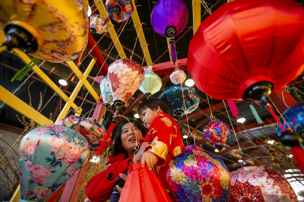 Ruy Gan and Demora Pham, 2, look at colorful lanterns at the Tet Festival at the OC Fairgrounds. 