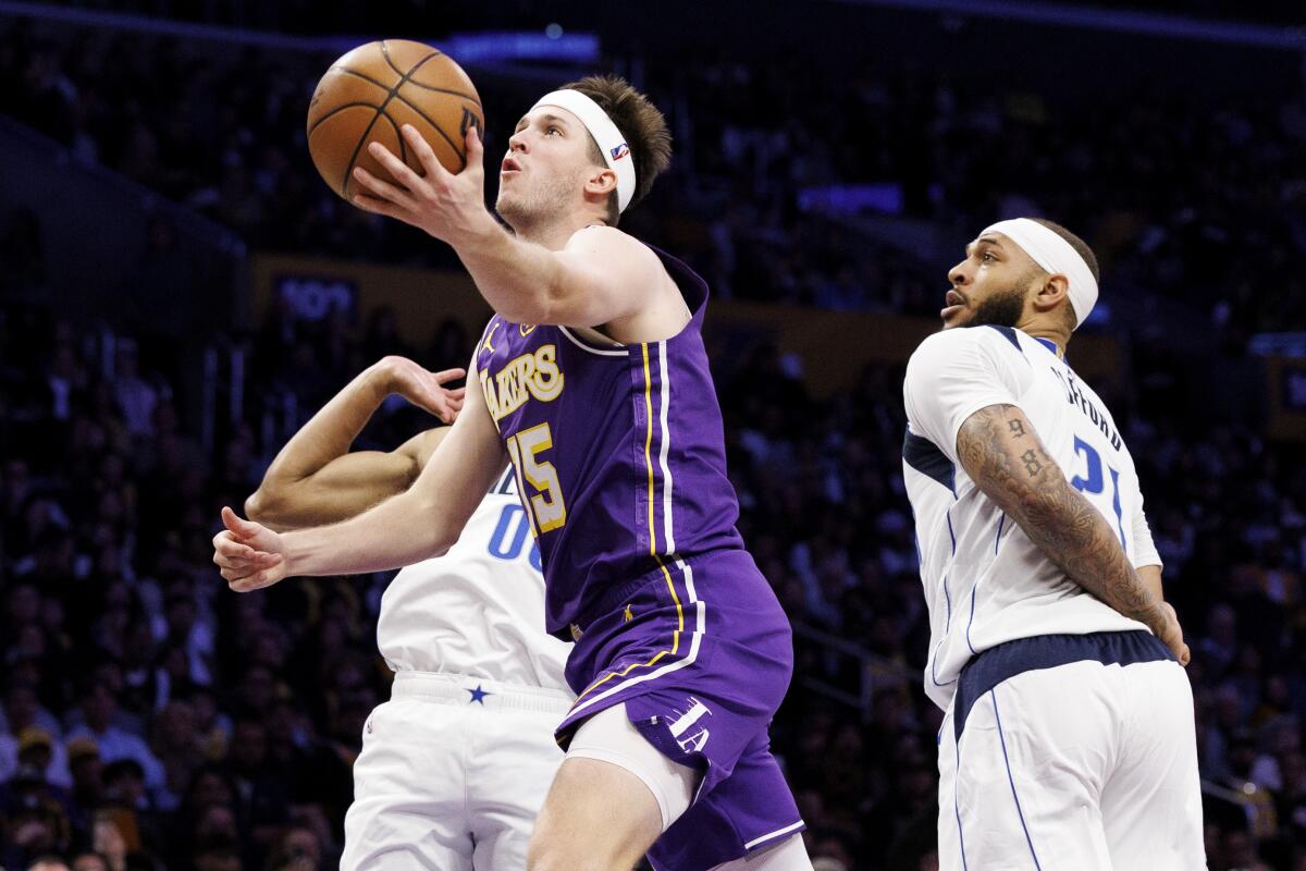 Austin Reaves drives to the basket between Dallas' Max Christie and Daniel Gafford in the first half.