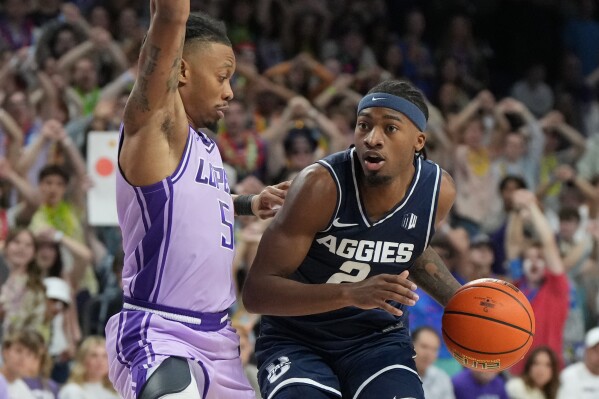 Utah State guard Mj Collins drives on Grand Canyon guard Brian Moore Jr. (5) during the first half of an NCAA college basketball game, Saturday, Jan. 17, 2026, in Phoenix. (AP Photo/Rick Scuteri)