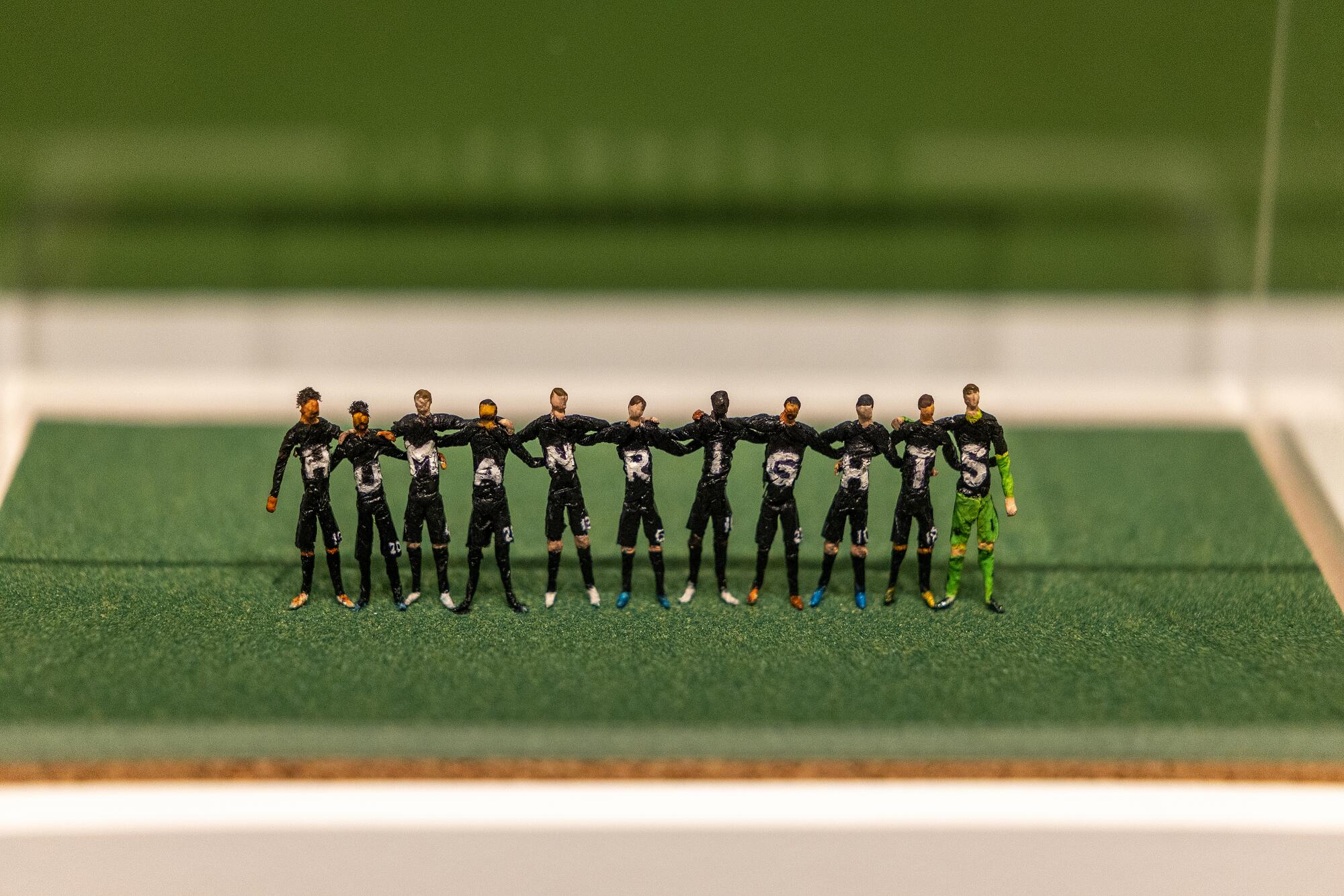 A detail of miniature figurines of the German soccer team wearing jerseys that read human rights.