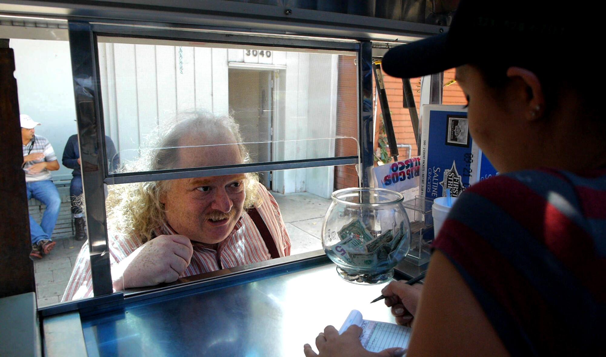 An eager eater looks inside a food truck.