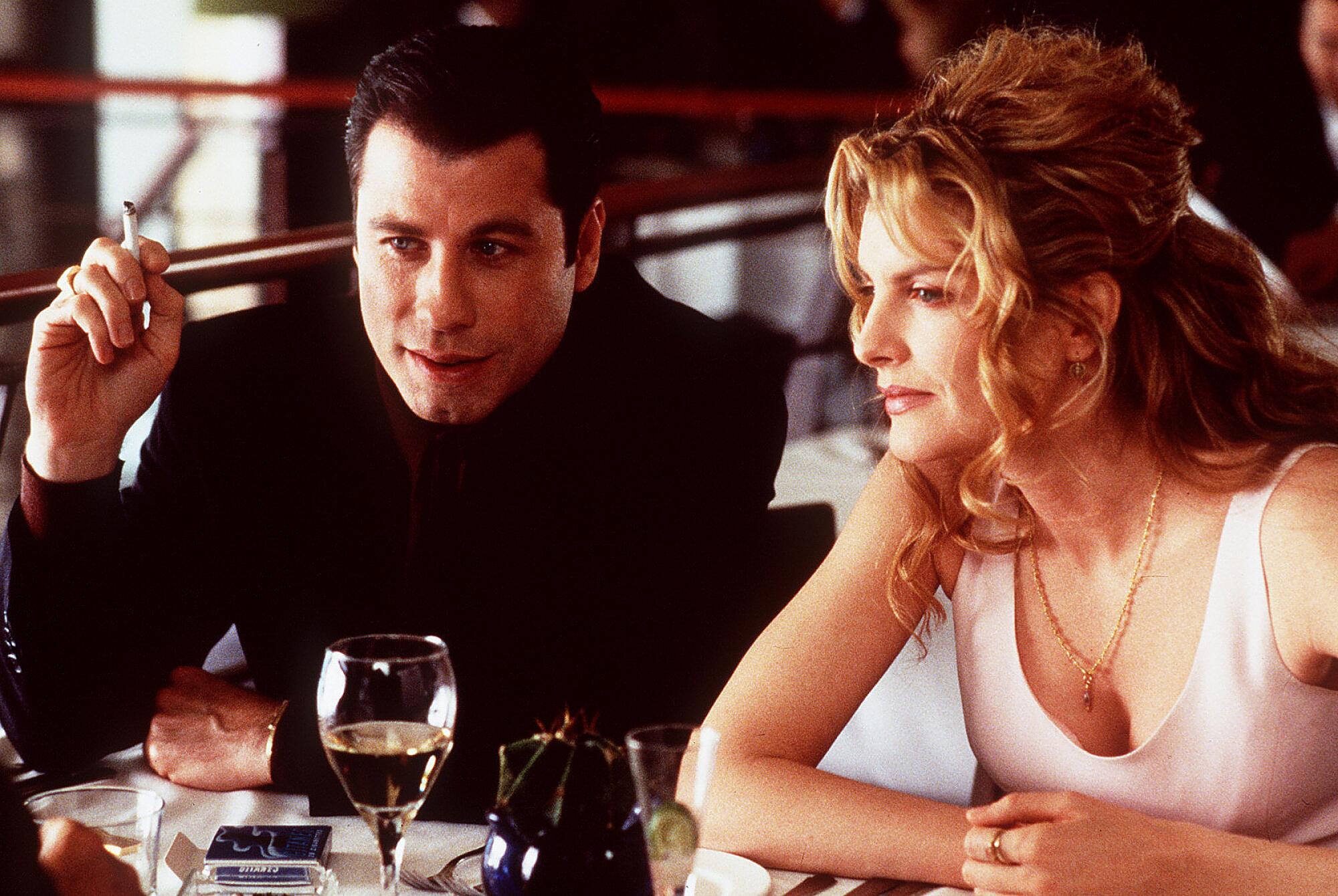 Two people flirt and cajole in a restaurant booth.