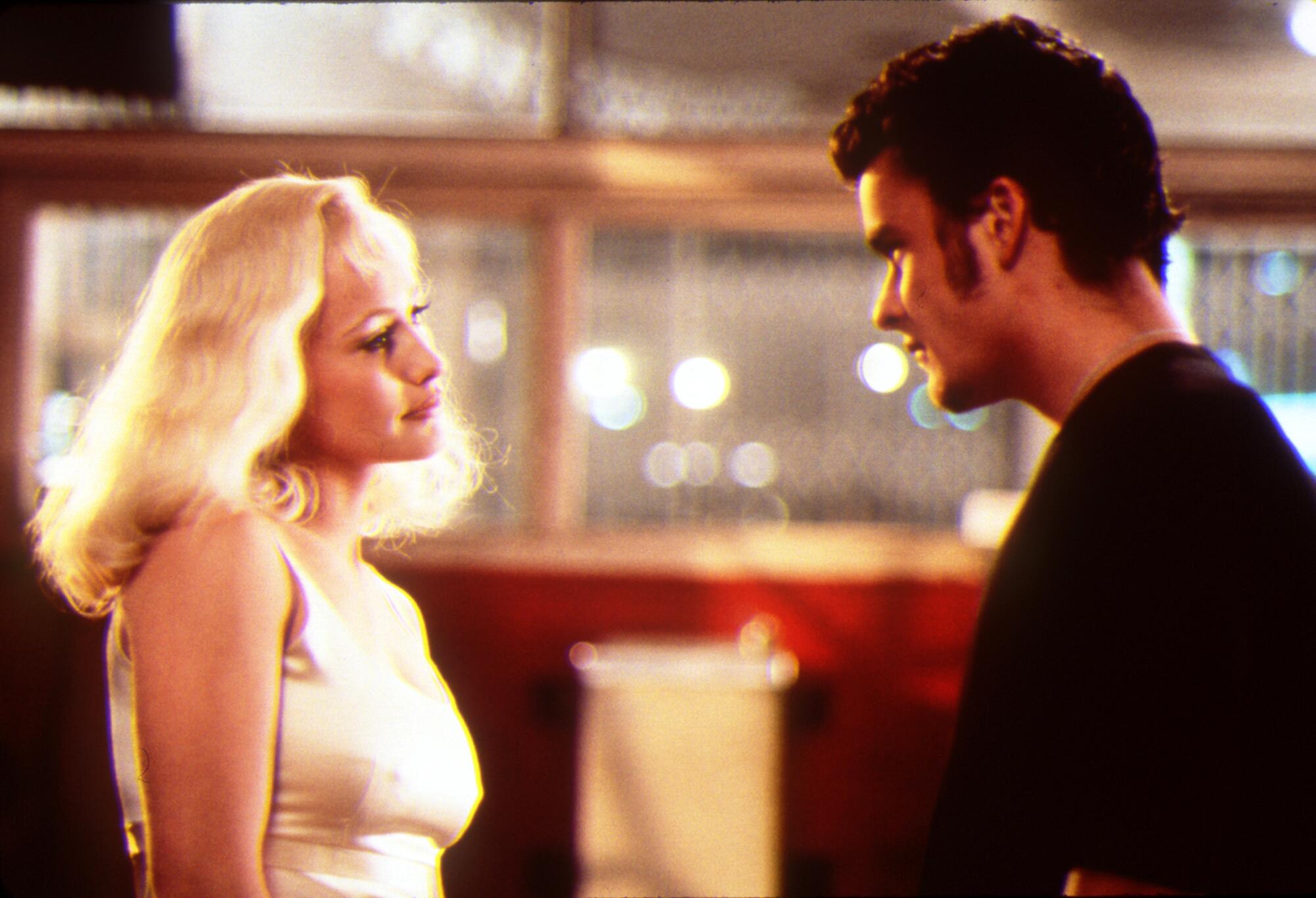 A blond woman flirts with a mechanic.