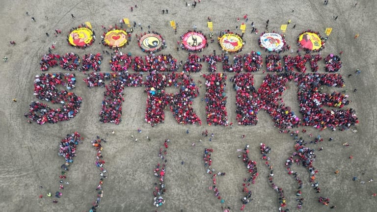 Hundreds of San Francisco teachers form a human banner spelling...