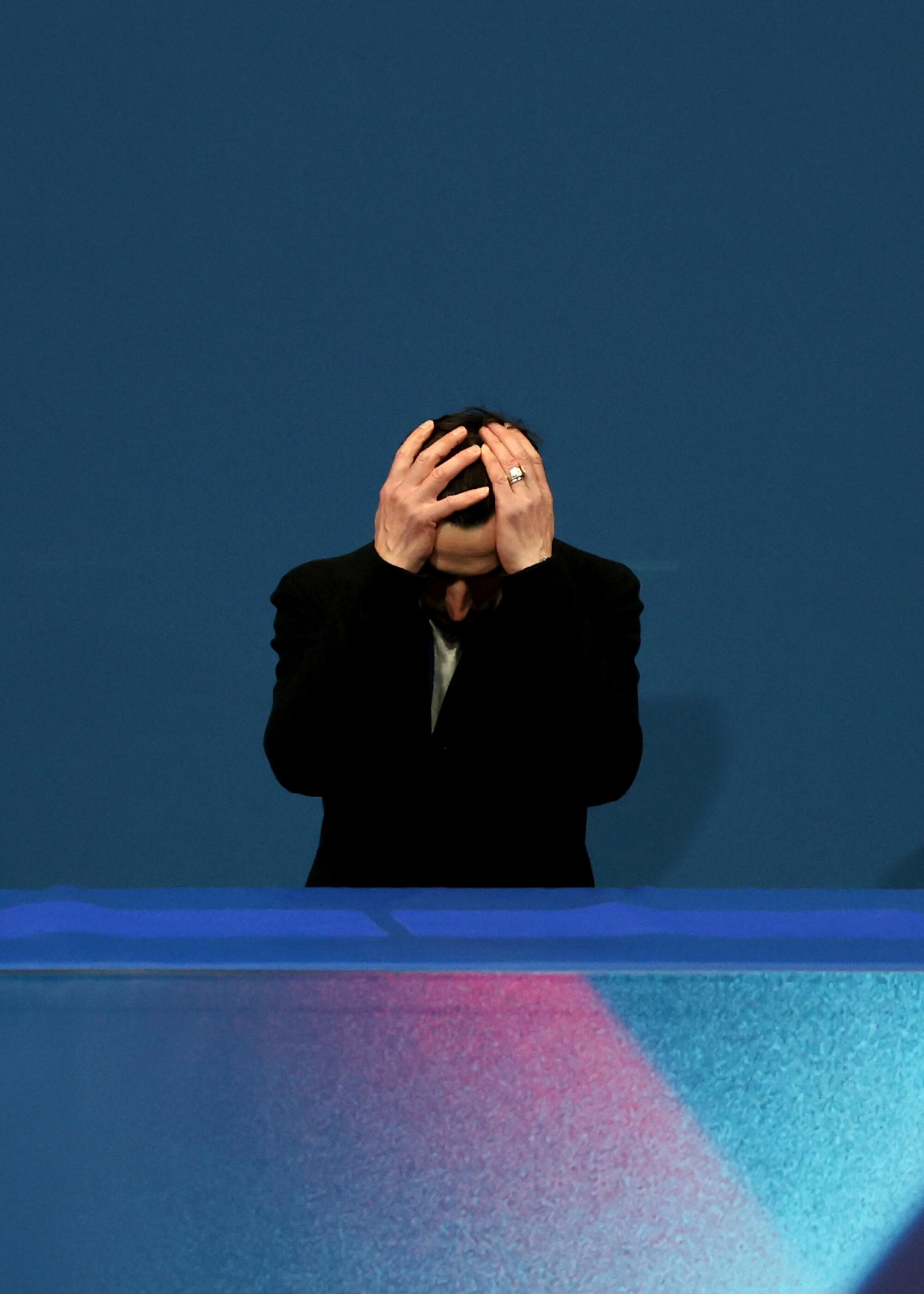 Ilia Malinin's father, Roman Skorniakov, holds his head in his hands during his son's stumbles at the Olympics