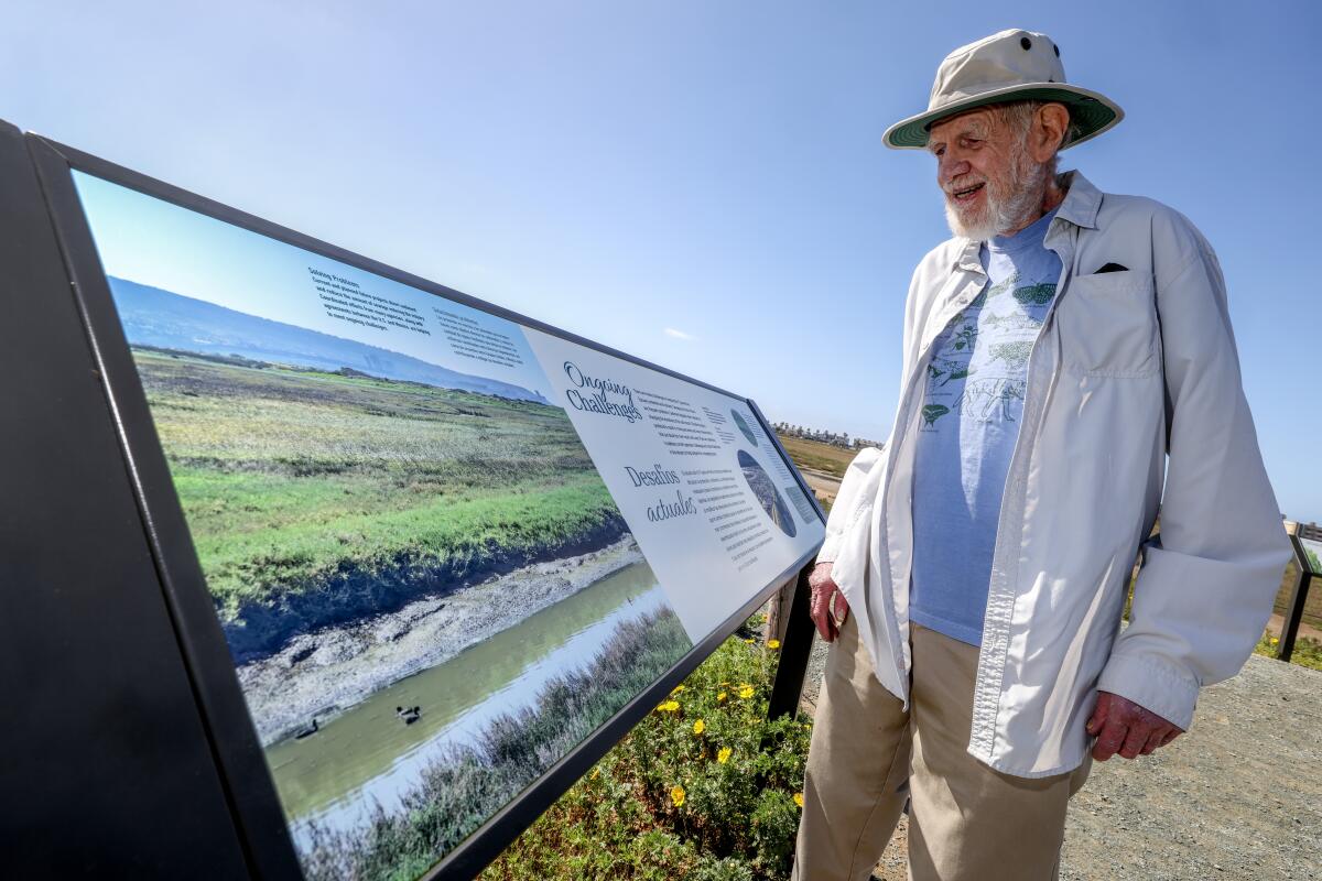 Coastal conservationist Mike McCoy looks at a new interpretive sign at the Tijuana Estuary in Imperial Beach.