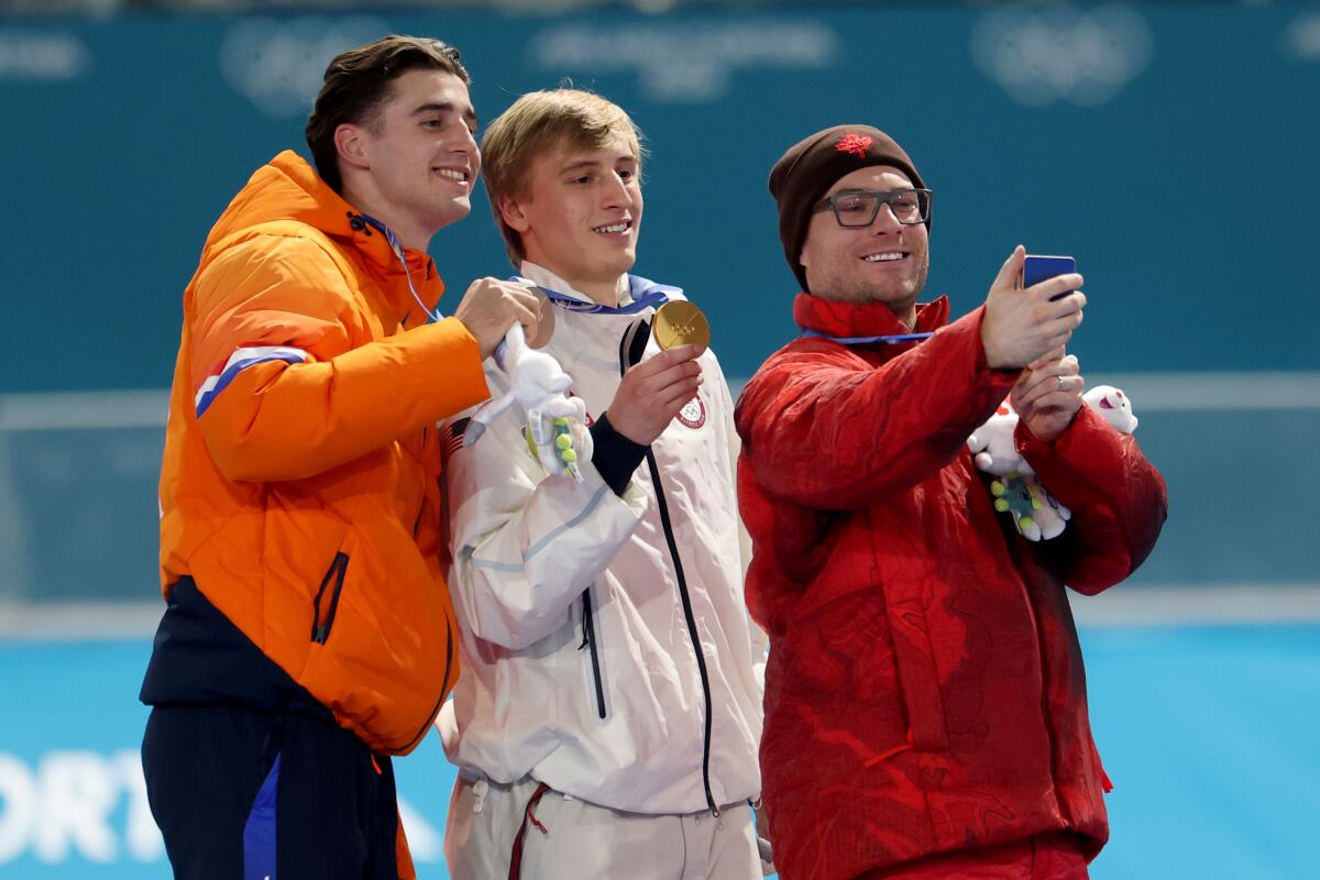 Gold medalist Jordan Stolz of the United States, center, celebrates on the podium.