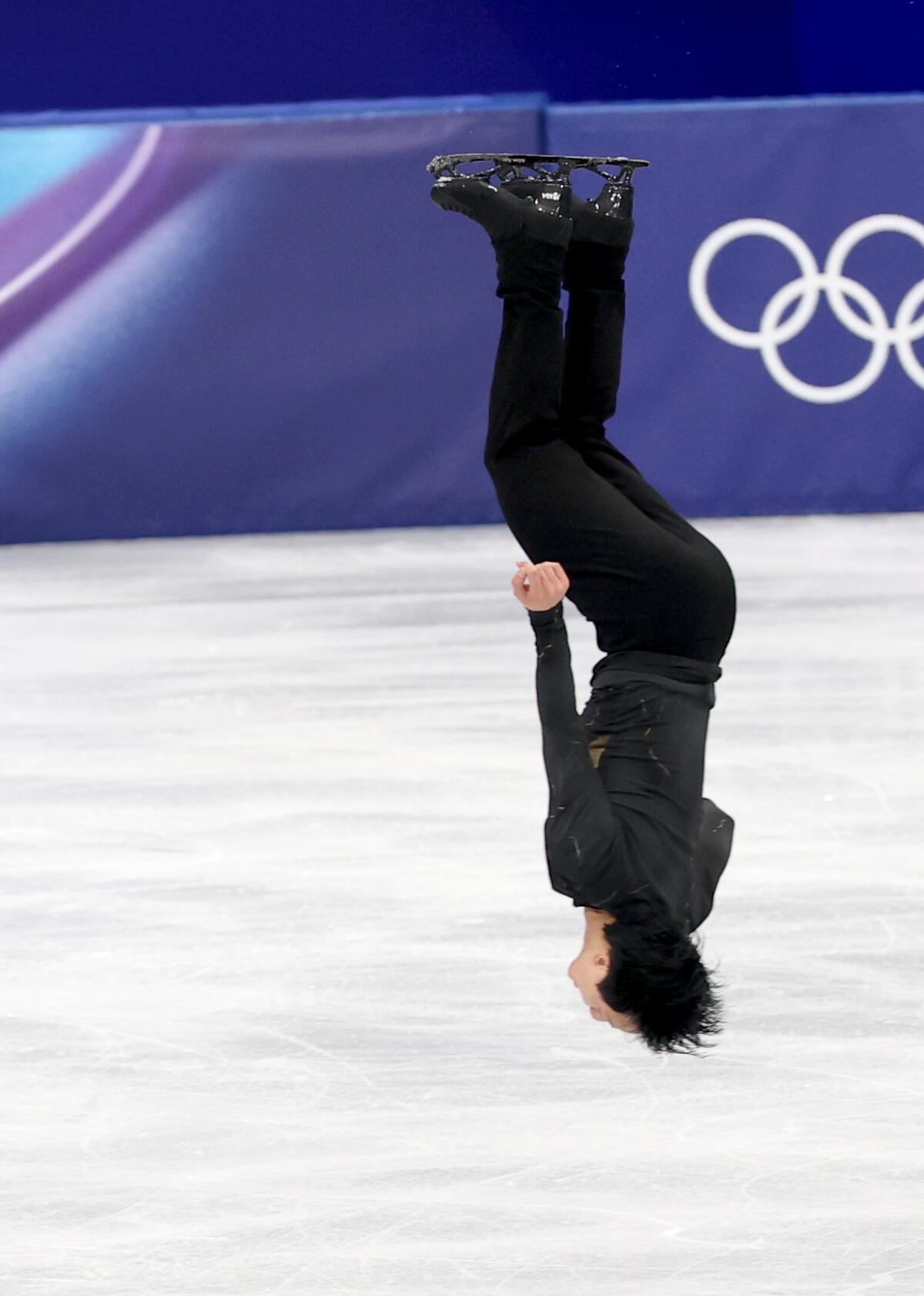 France's Adam Siao Him Fa performs a backflip while competing in the figure skating men's free skate Friday.