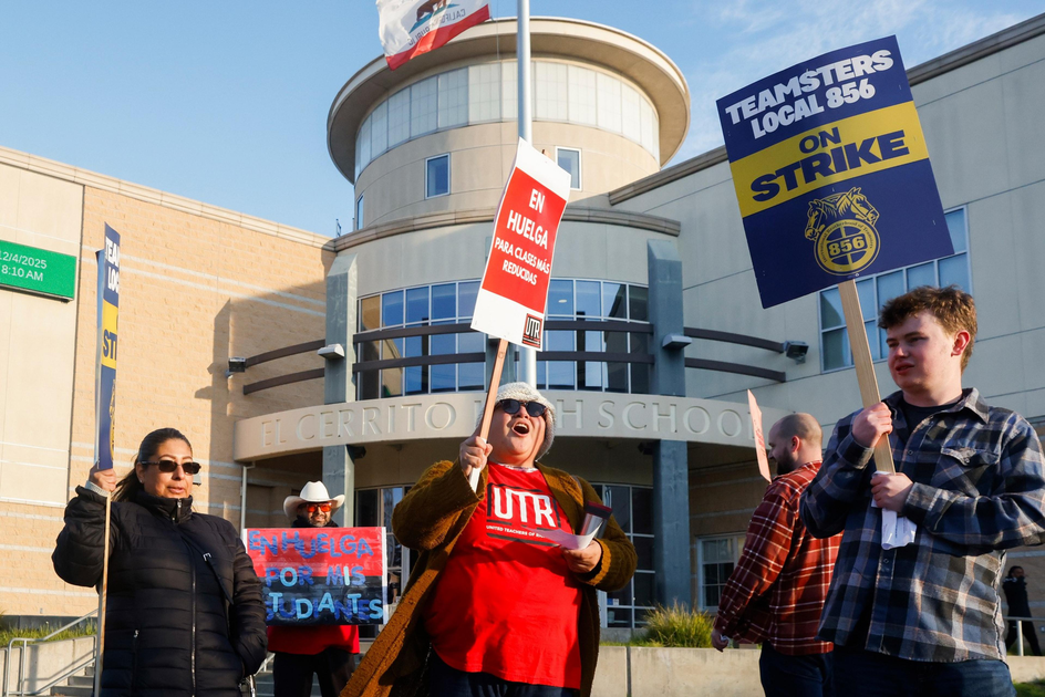 People hold strike signs in front of El Cerrito High School, protesting for better wages and support for students.