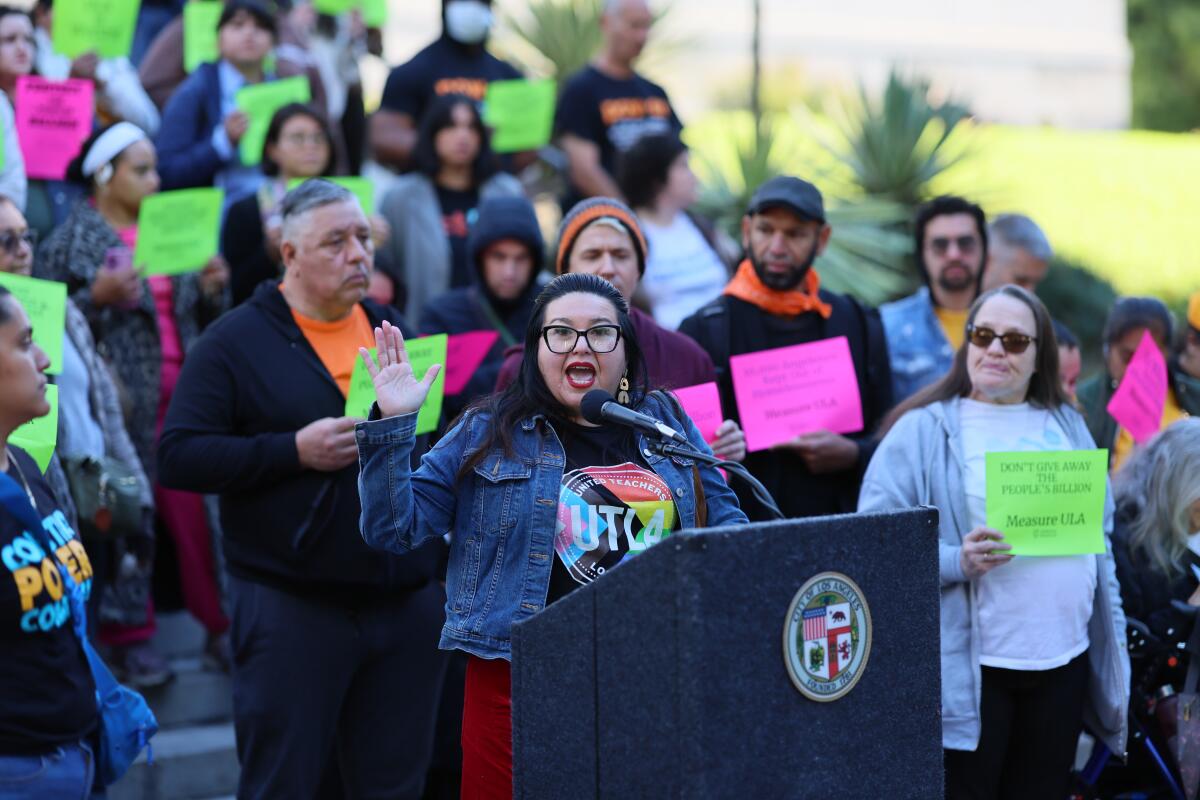 Gloria Martinez, center, of United Teachers Los Angeles, speaks at a rally outside City Hall.