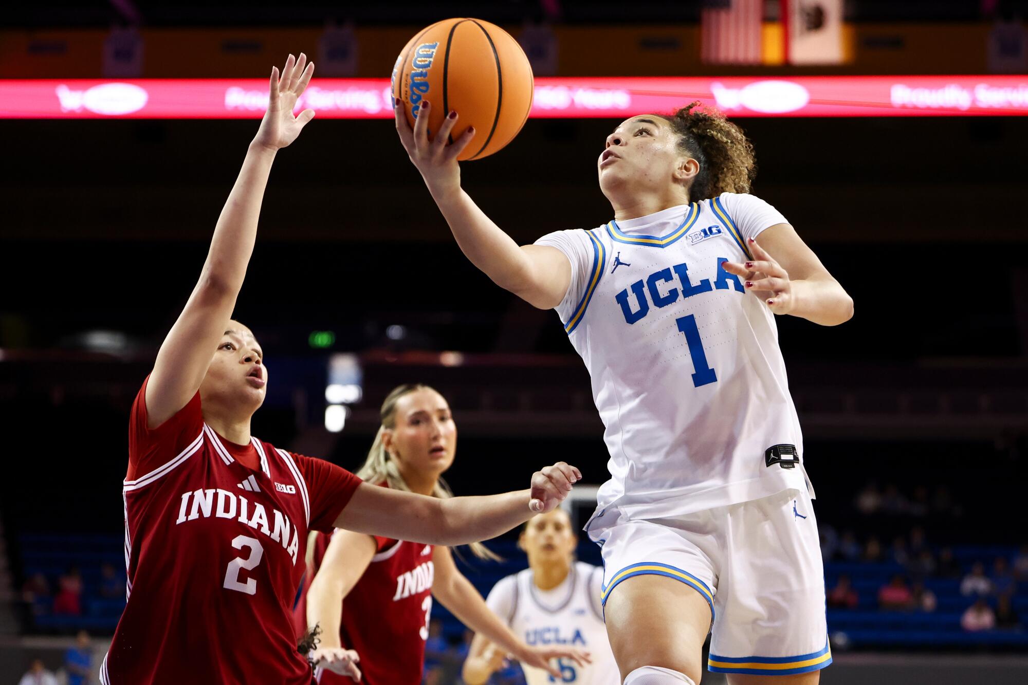 UCLA guard Kiki Rice drives to the basket under pressure from Indiana's Nevaeh Caffey.