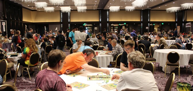 A large convention room full of people playing board games.