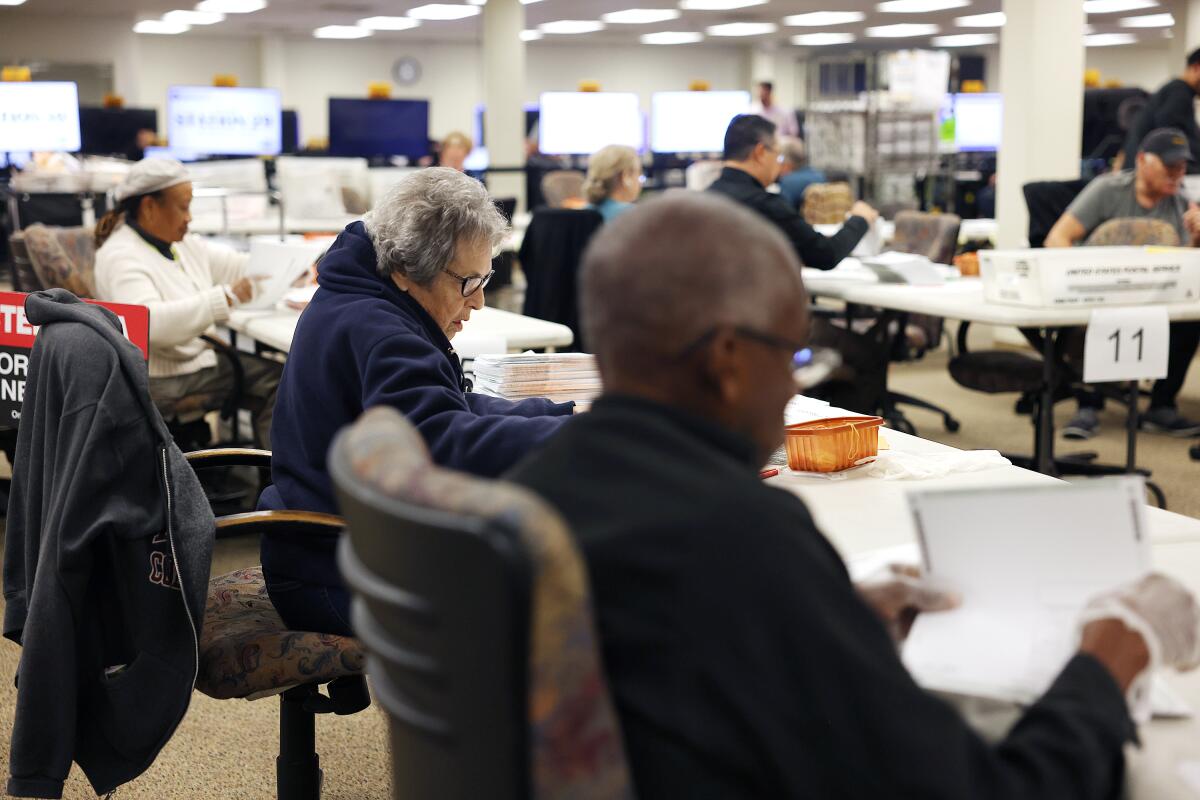 Registrar voter staff members process ballots