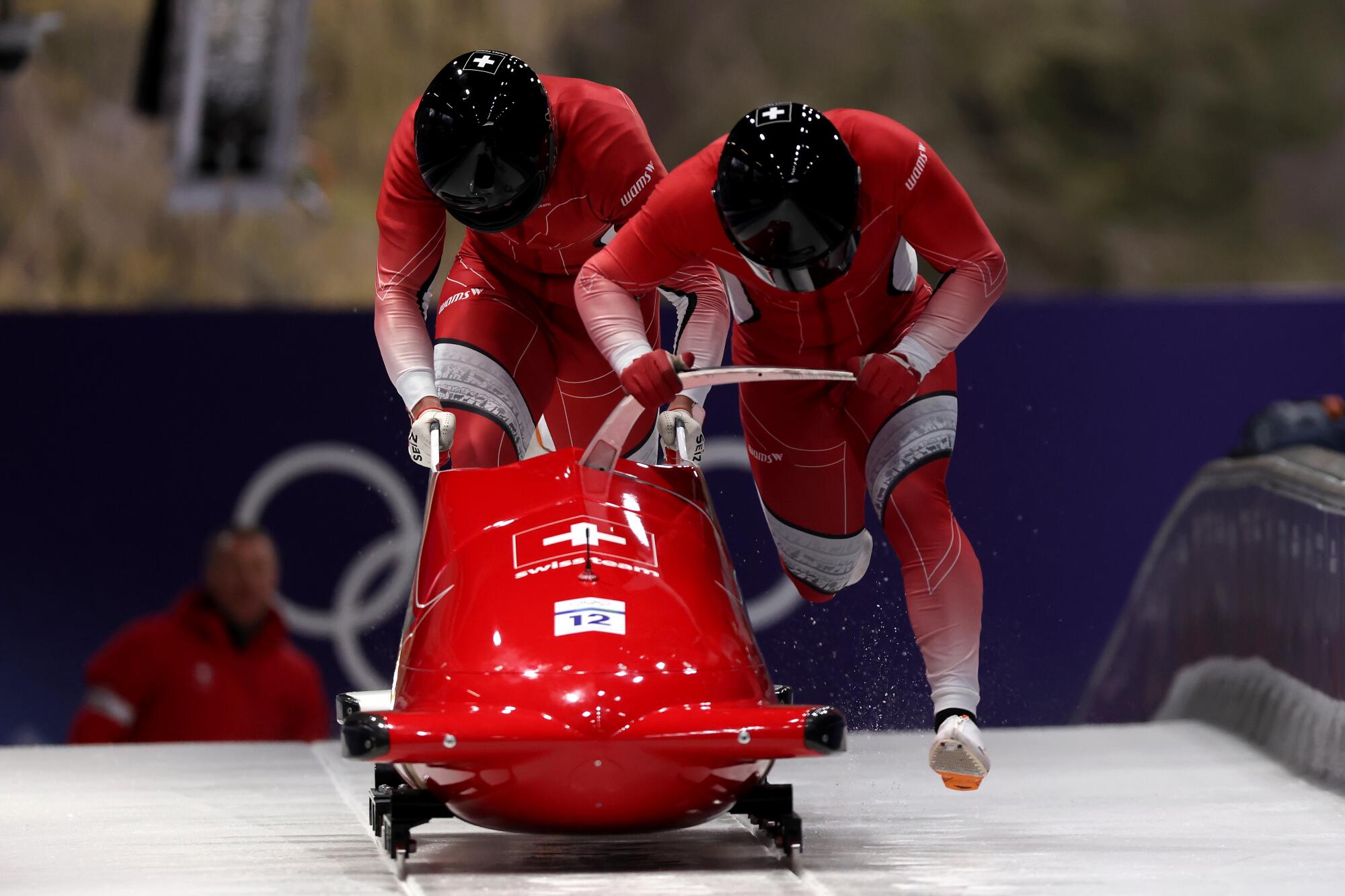 Switzerland's Cedric Follador, right, and Luca Rolli compete in two-man bobsled at the Milan-Cortina Olympics on Monday.