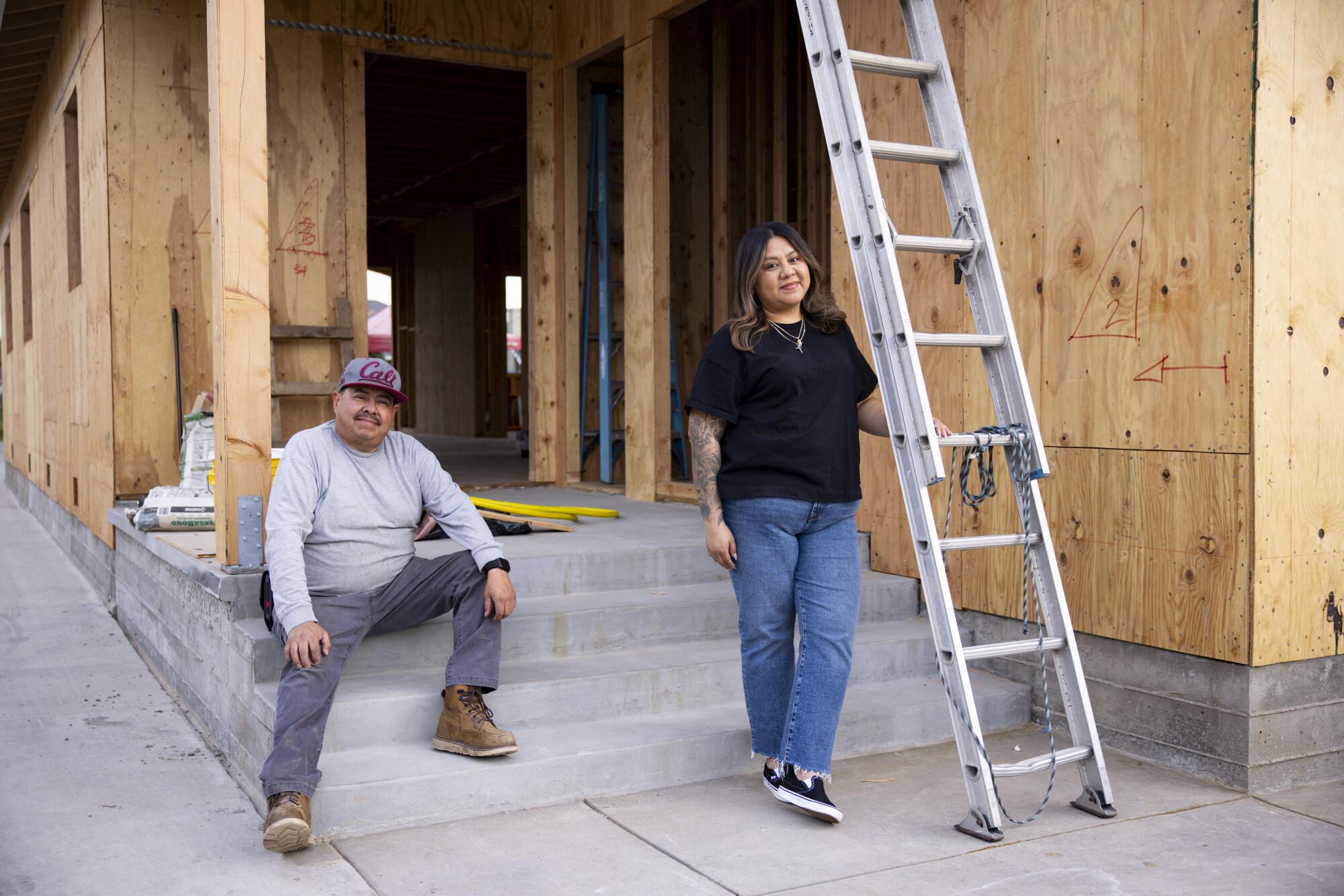 Jose Cervantes and his daughter Jessica outside a home under construction