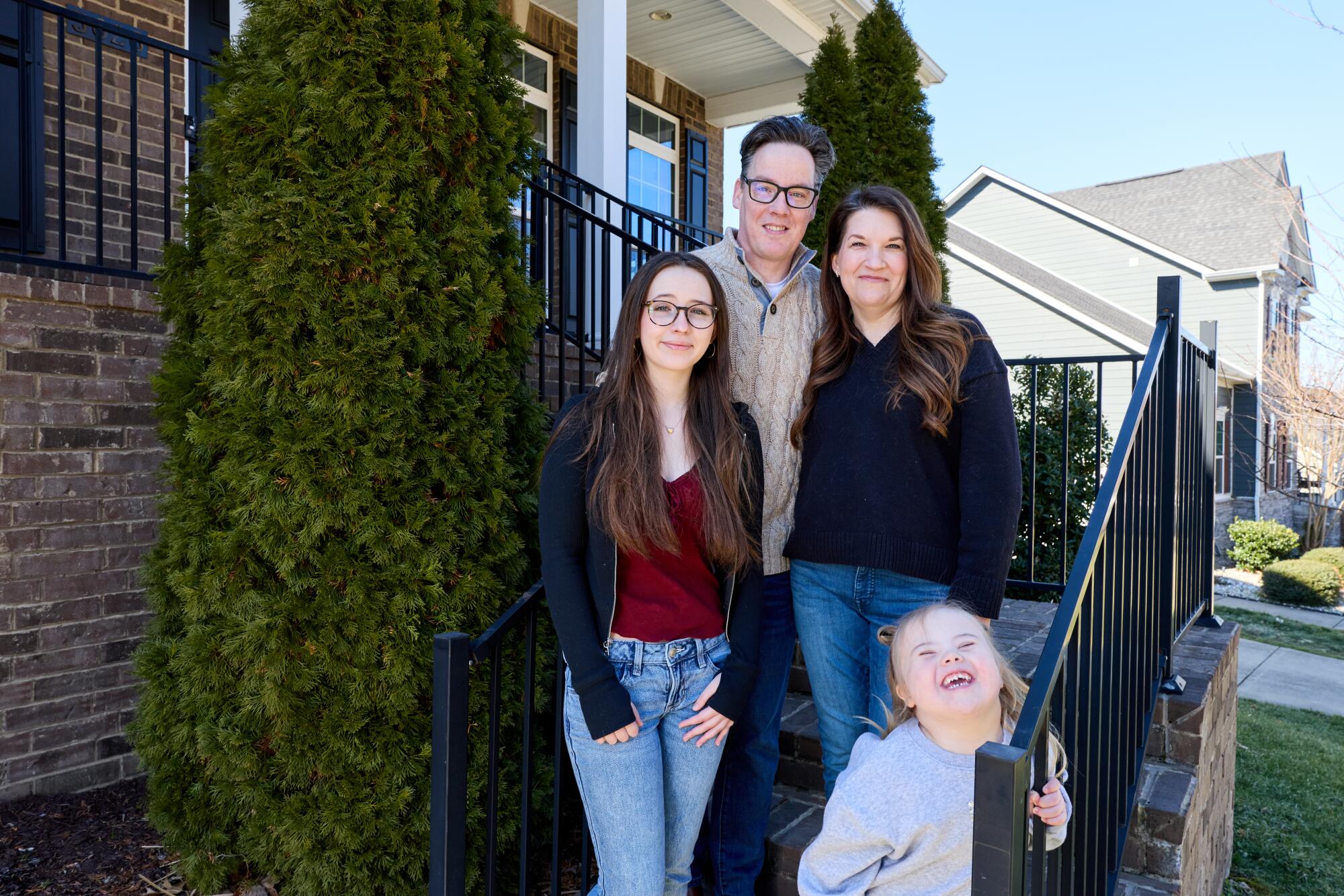 The McIntire family outside a brick home