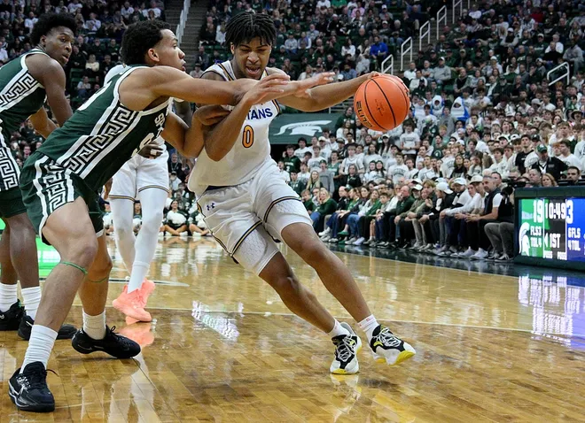 Nov 13, 2025; East Lansing, Michigan, USA; San Jose State Spartans guard Colby Garland (0) dribbles against Michigan State Spartans guard Divine Ugochukwu (99) during the first half at Jack Breslin Student Events Center.