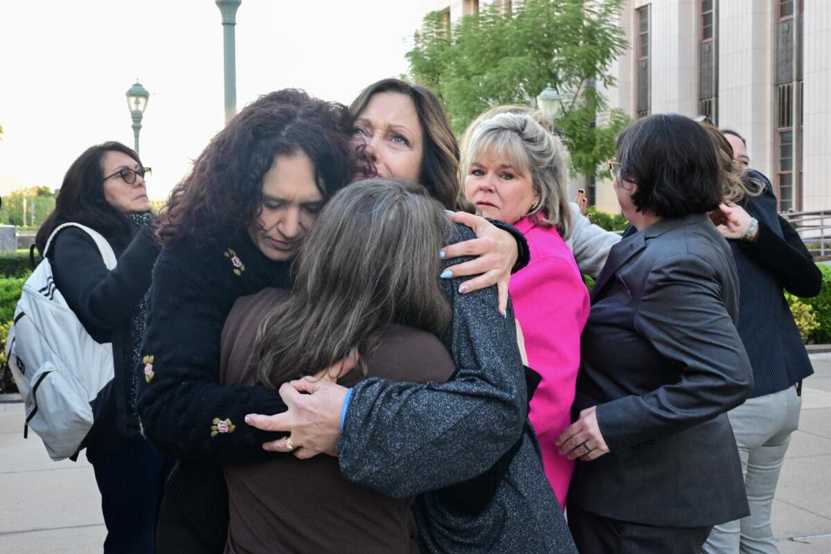 Parents and family members, including some plaintiffs in the case, embrace before entering the Los Angeles Superior Court