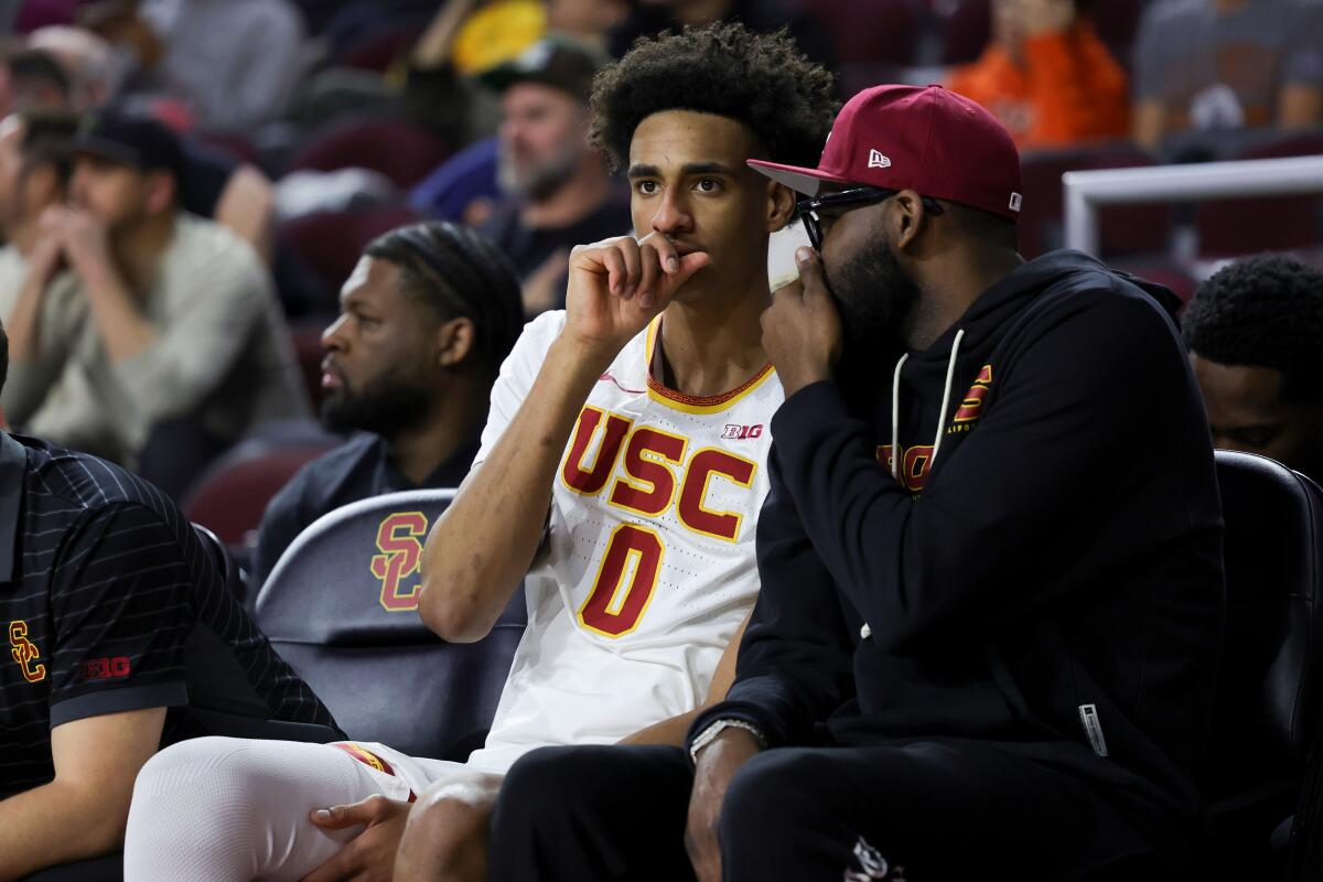 Alijah Arenas watches from the bench during the second half.