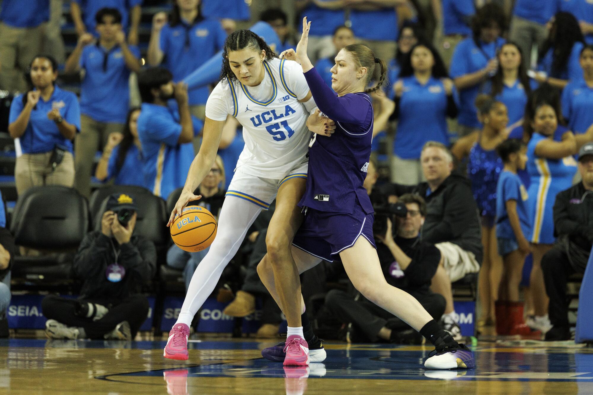 UCLA center Lauren Betts drives to the basket under pressure from Washington center Yulia Grabovskaia.