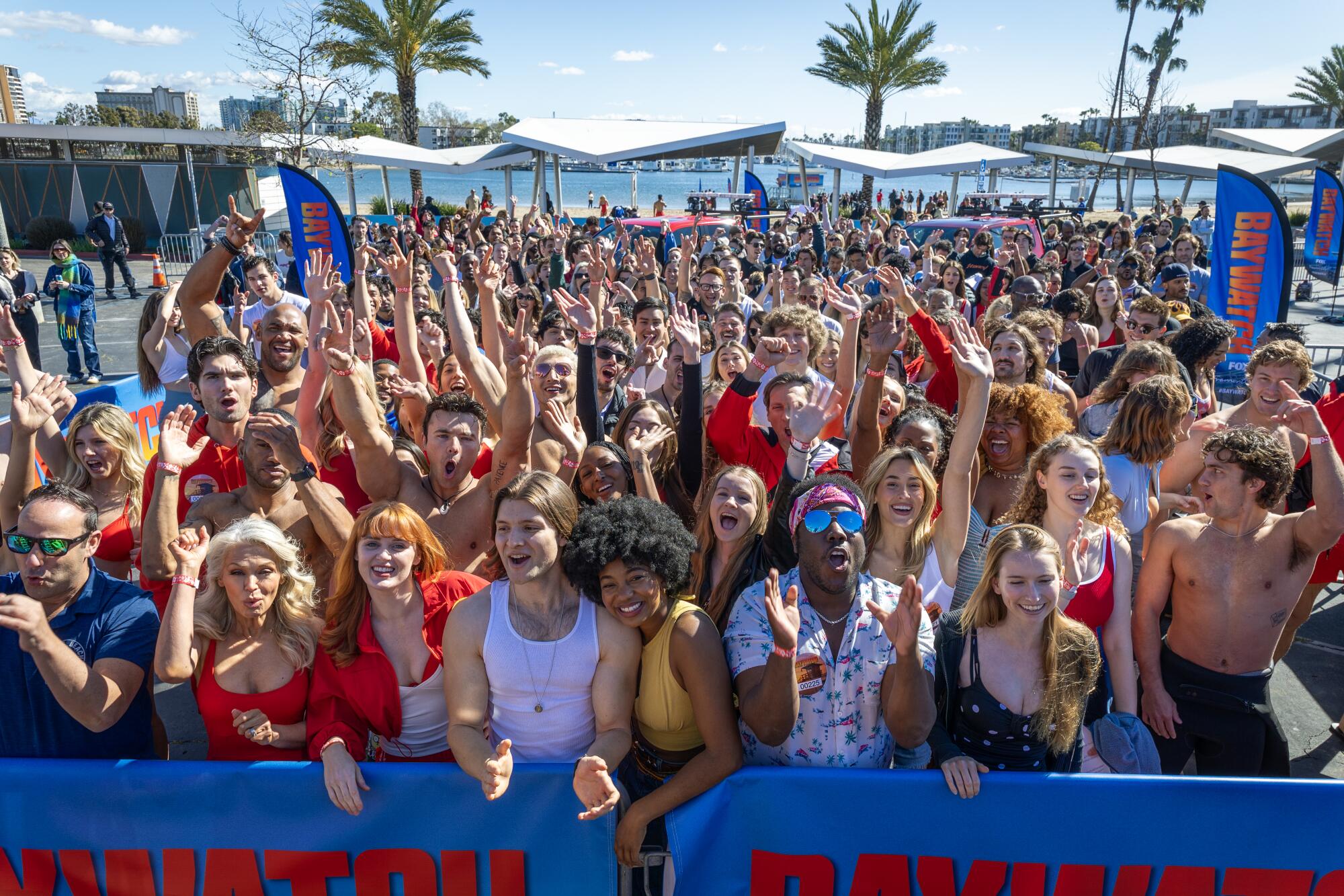 A crowd of people standing together behind some barricades.