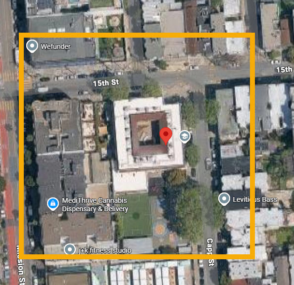 A satellite map view of a city block, bordered in yellow, highlights buildings, trees, labeled locations—including Marshall—and a red location marker at the center.