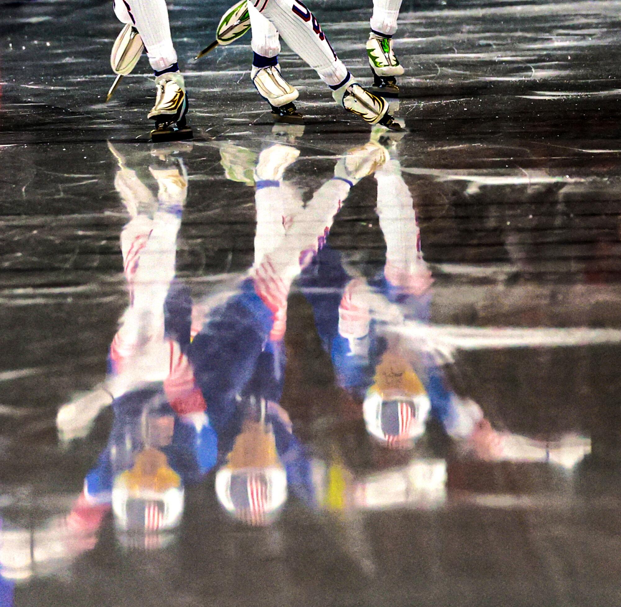 Team USA are reflected in the ice during the Women's Team Pursuit at Milano Speed Skate Stadium.
