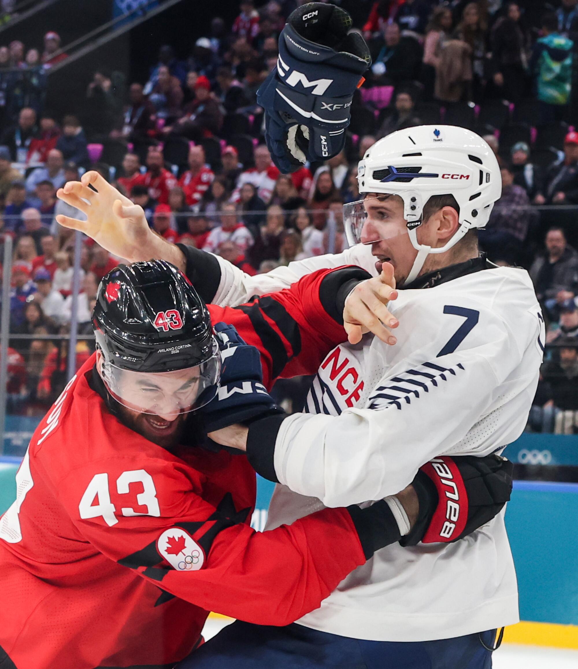 Tom Wilson, left, of Team Canada engaged with Pierre Crinon, of Team France, at Milano Santagiulia Ice Hockey Arena.