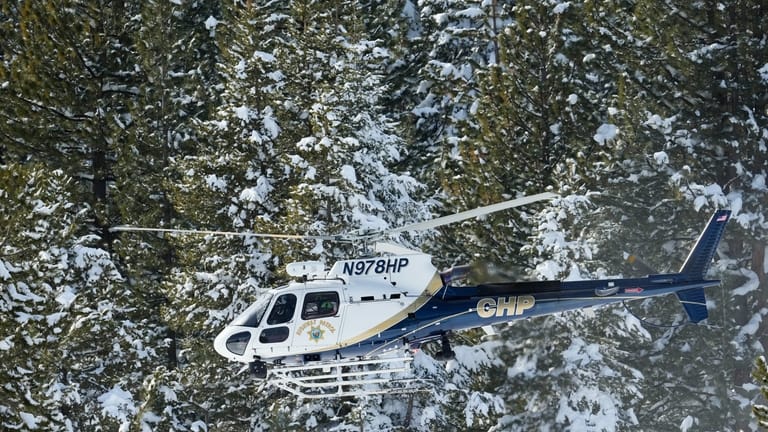 A California Highway Patrol search and rescue crew flies over...