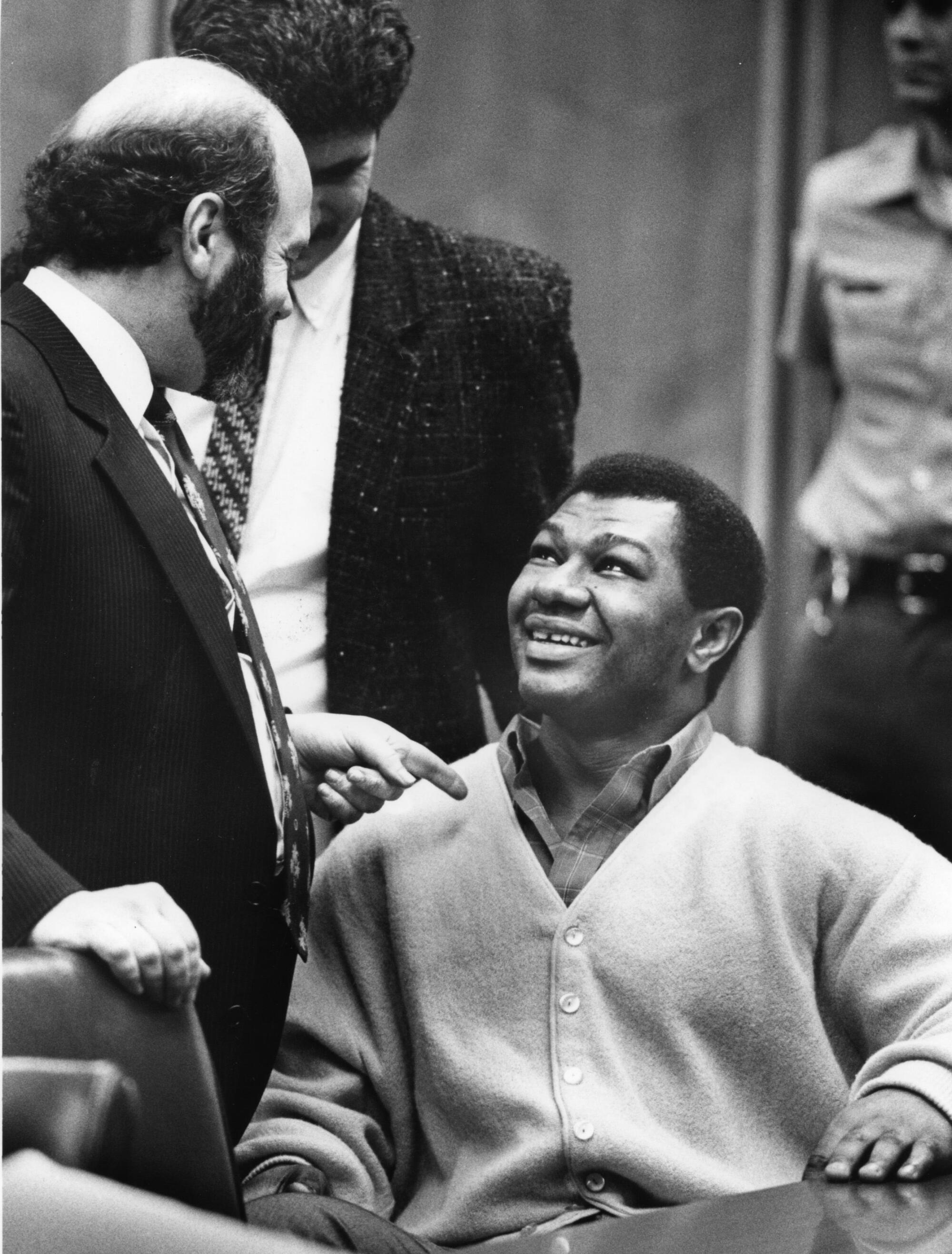 James Pittman, seated, smiles at his attorney Jeffrey Brody in court