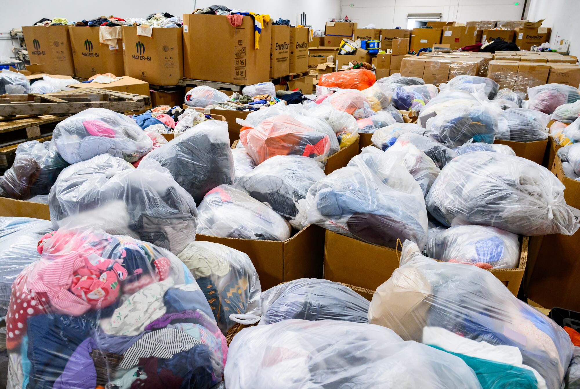 Bagged recyclables fill the floor of a room 