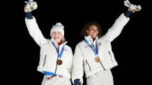 Bronze medalists Kaillie Armbruster Humphries and Jasmine Jones of Team United States celebrate on the podium during the medal ceremony for the Bobsleigh Two-Woman event.