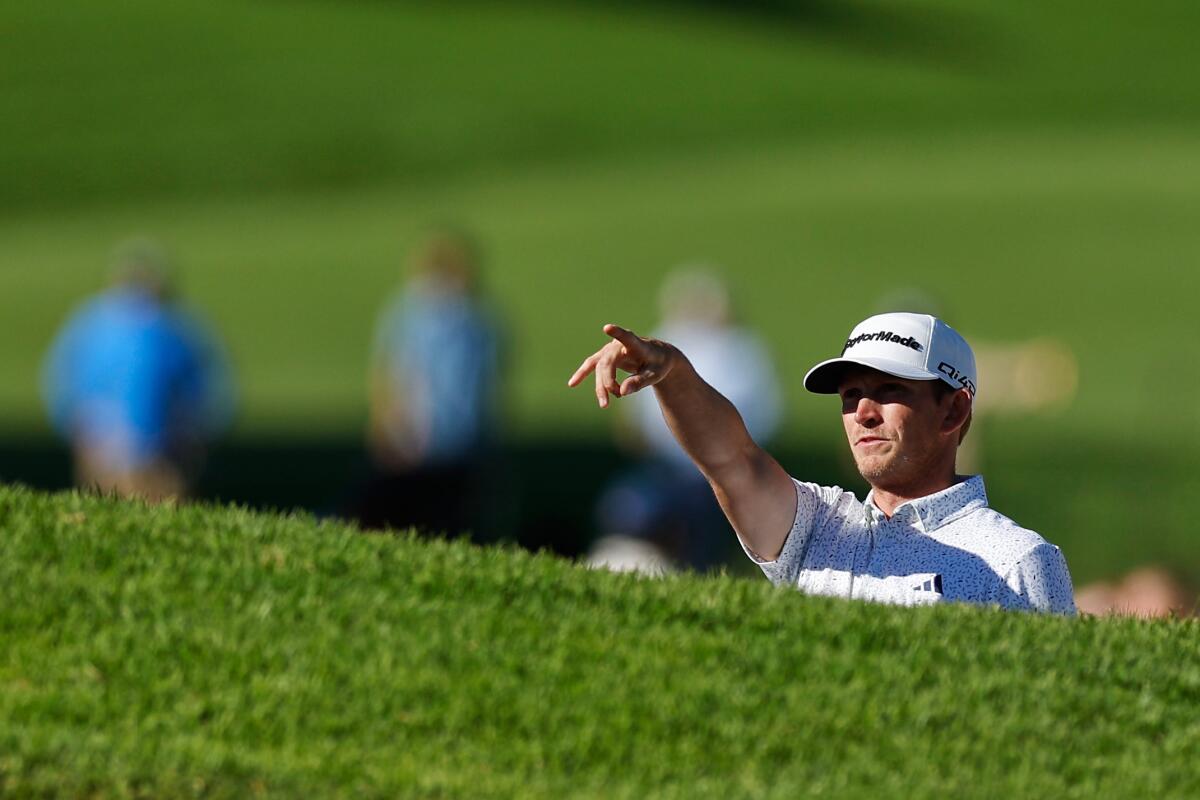 Jacob Bridgeman points toward the hole from a bunker on the 14th hole at Riviera Country Club.