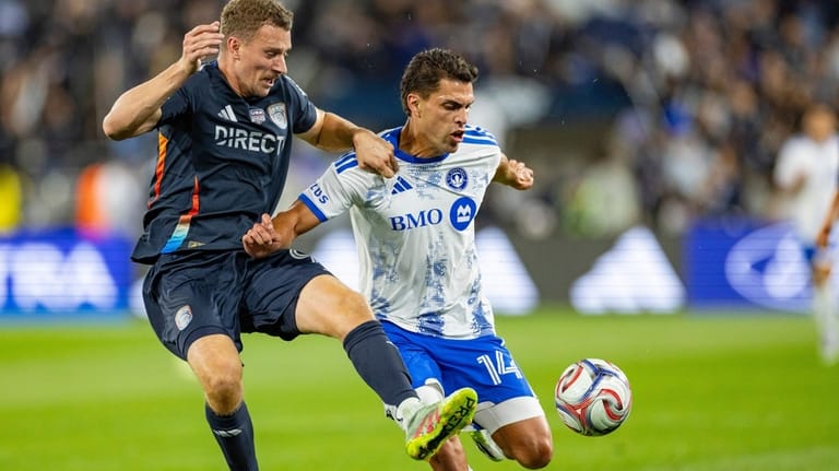San Diego FC defender Christopher McVey, left, challenges for the...
