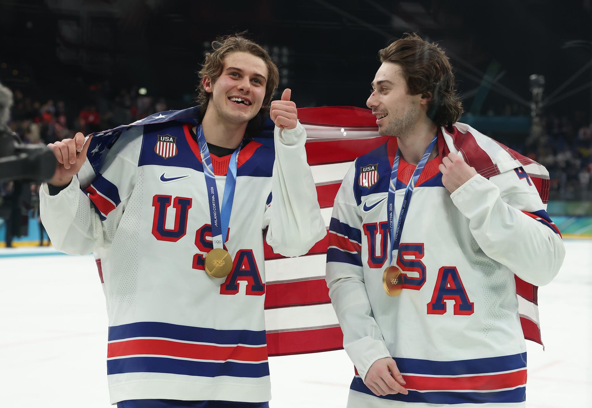 Brothers Jack, left, and Quinn Hughes celebrate after winning gold medals at the Milan-Cortina Olympics on Sunday.