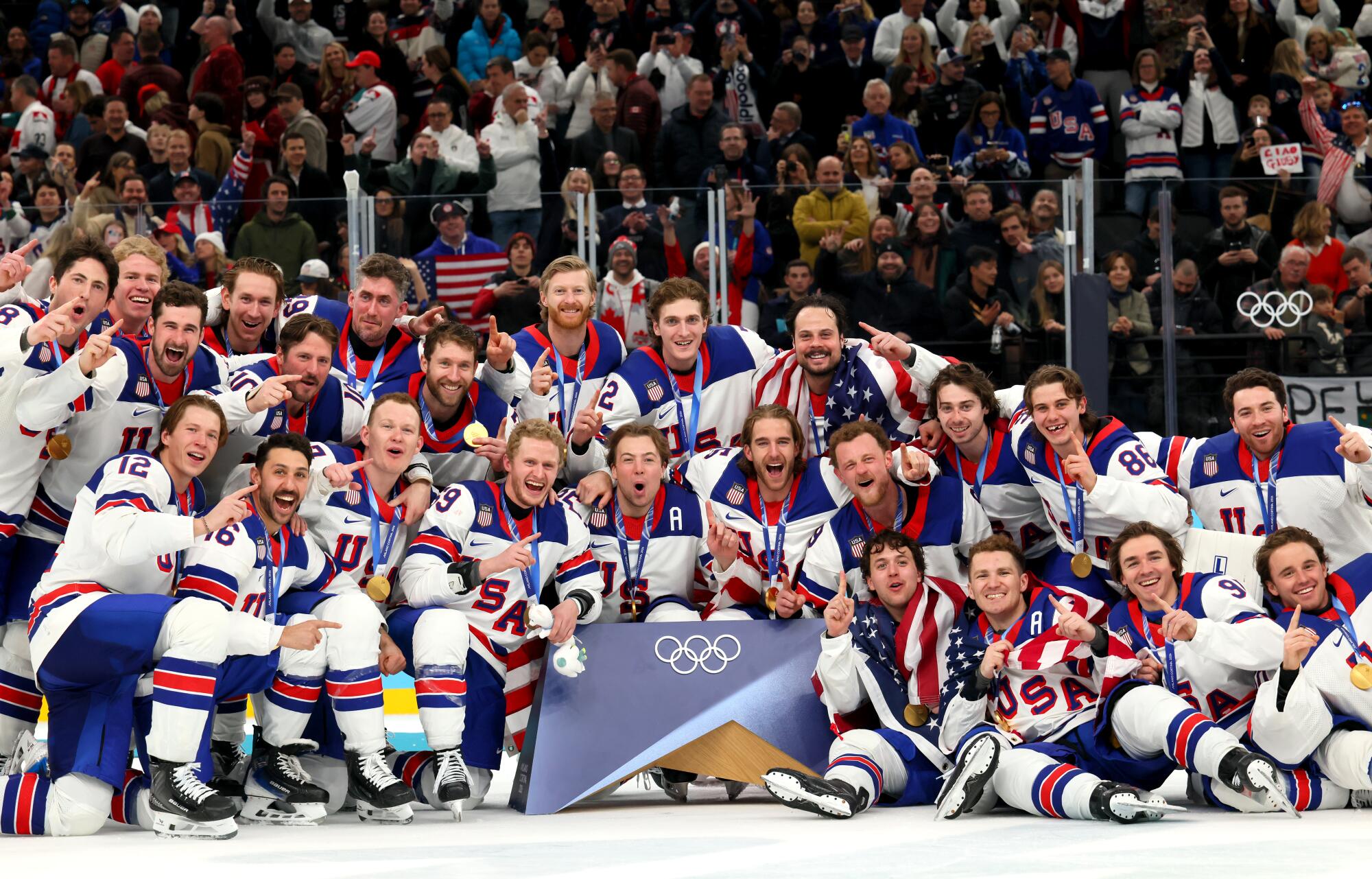 United States players pose for a photo after defeating Canada for the gold medal at the Milan-Cortina Games on Sunday.